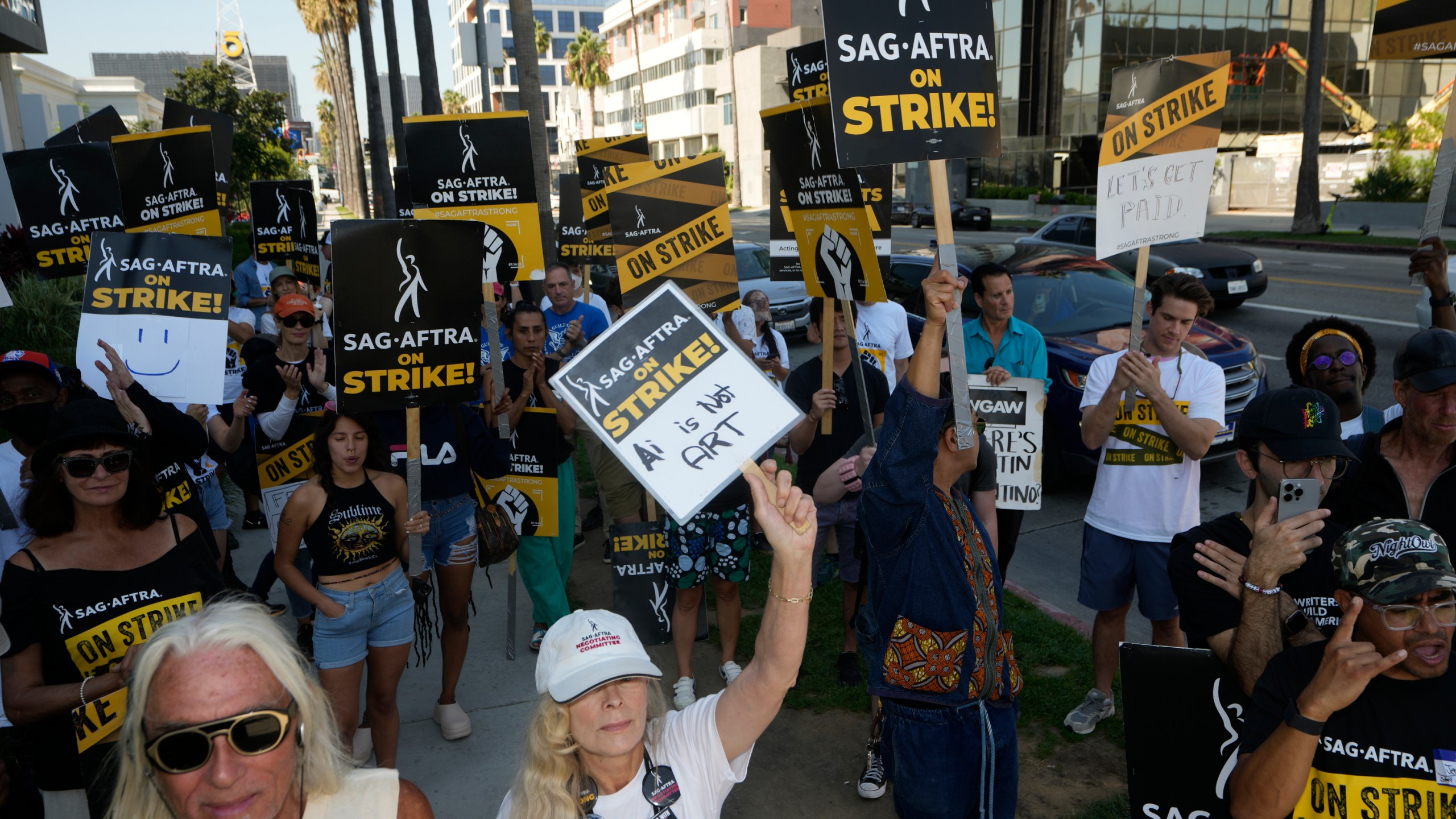 Actor and SAG-AFTRA negotiator Frances Fisher, middle, raises her sign on a picket line outside Netflix studios on Tuesday, Sep. 26, 2023, in Los Angeles. (AP Photo/Damian Dovarganes)