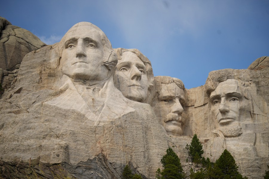 FILE - Visitors take in the massive sculpture carved into Mount Rushmore at the Mount Rushmore National Memorial Thursday, Sept. 21, 2023, in, Keystone, S.D. Gates will be locked and thousands of rangers will be furloughed from national park sites if Congress doesn’t reach a budget agreement Sunday, Oct. 1, 2023. But Arizona and Utah officials say they’ll make sure visitors can still enjoy the dramatic depths of the Grand Canyon and the soaring red cliffs of Zion Valley and South Dakota says it will pay to keep Mount Rushmore and Badlands accessible. (AP Photo/David Zalubowski, File)