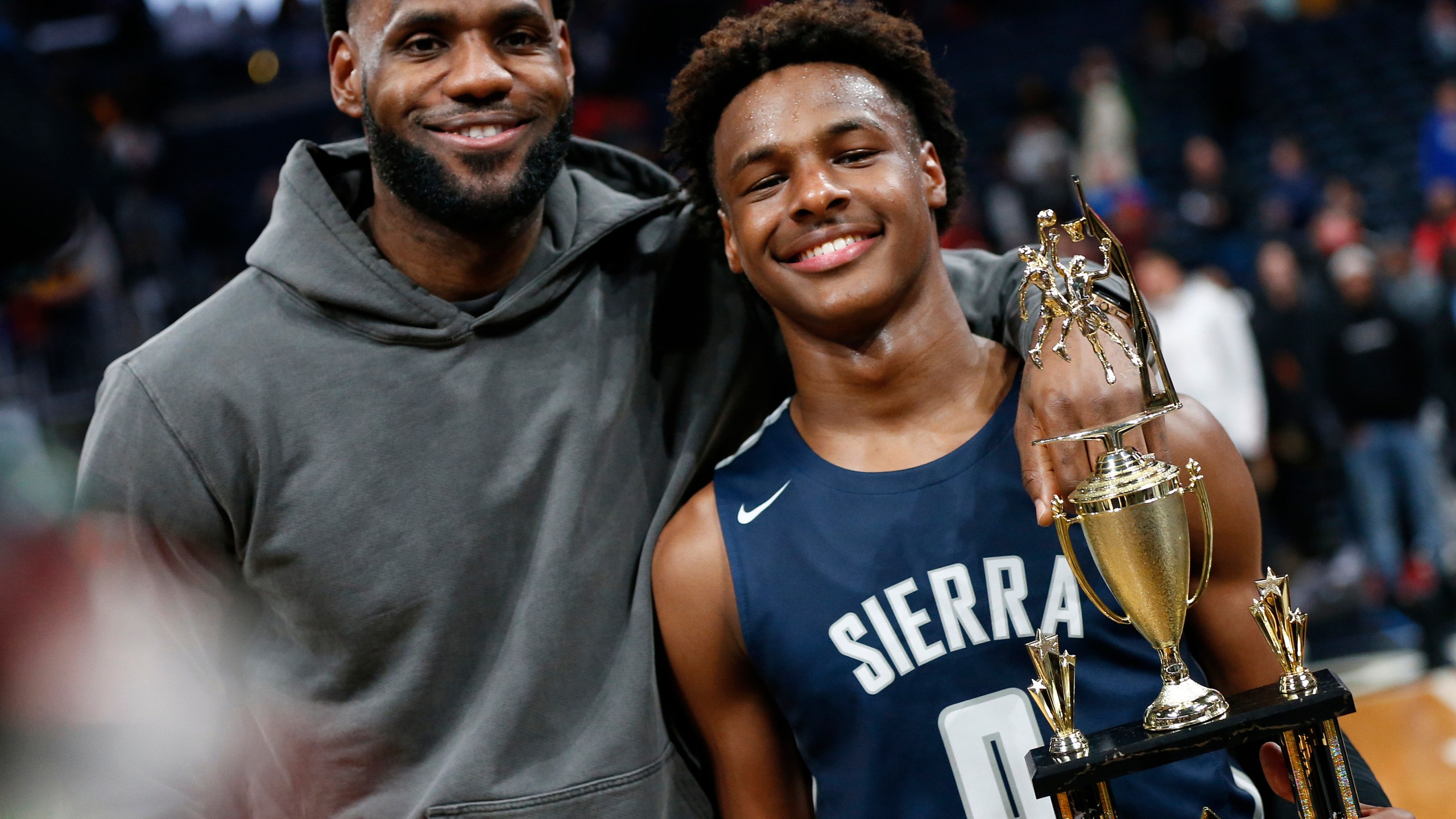 FILE - LeBron James, left, poses with his son Bronny after Sierra Canyon beat Akron St. Vincent - St. Mary in a high school basketball game, Saturday, Dec. 14, 2019, in Columbus, Ohio. LeBron James says his son, Bronny, is progressing in his rehabilitation from cardiac arrest in hopes of playing for the University of Southern California this season. James gave the update on his 18-year-old son Monday, Oct. 2, 2023, when the Los Angeles Lakers held their annual media day ahead of training camp. (AP Photo/Jay LaPrete, File)