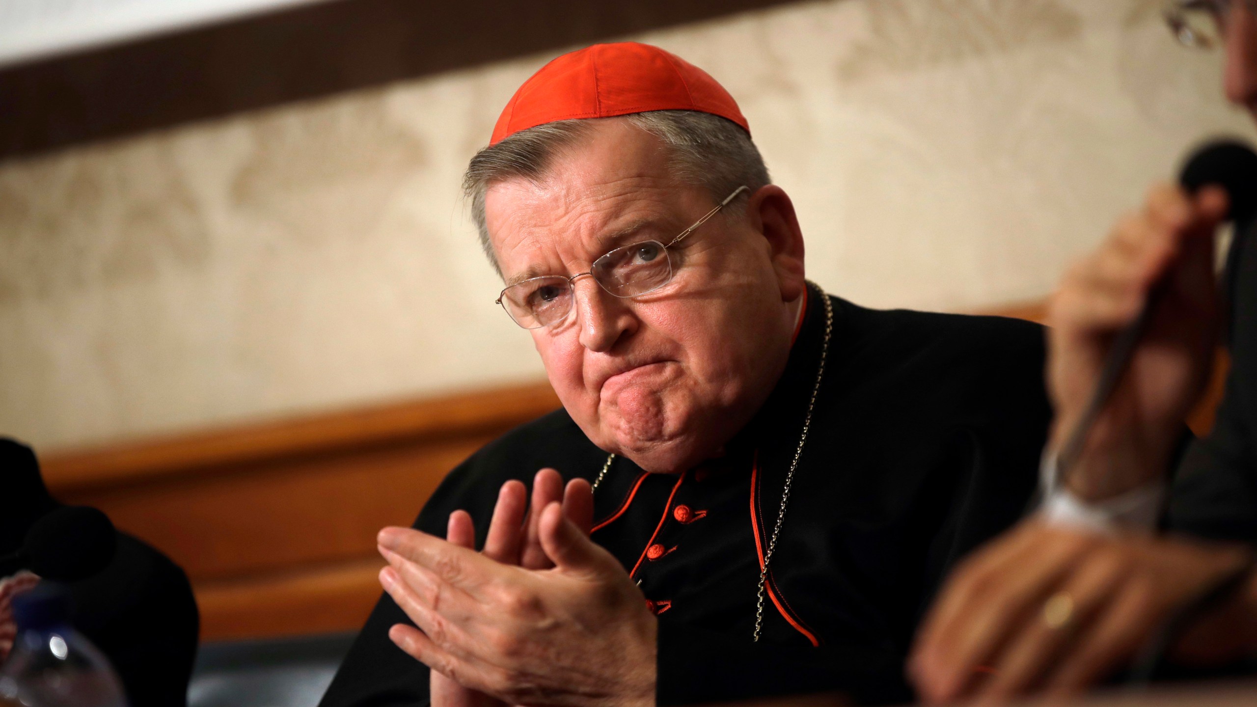 FILE - In this Sept. 6, 2018 file photo, Cardinal Raymond Burke applauds during a news conference at the Italian Senate, in Rome. Five conservative cardinals are challenging Pope Francis to affirm Catholic teaching on homosexuality and female ordination. They've asked him to respond ahead of a big Vatican meeting where such hot-button issues are up for debate. The cardinals on Monday published five questions they submitted to Francis, known as “dubia.” (AP Photo/Alessandra Tarantino, File)