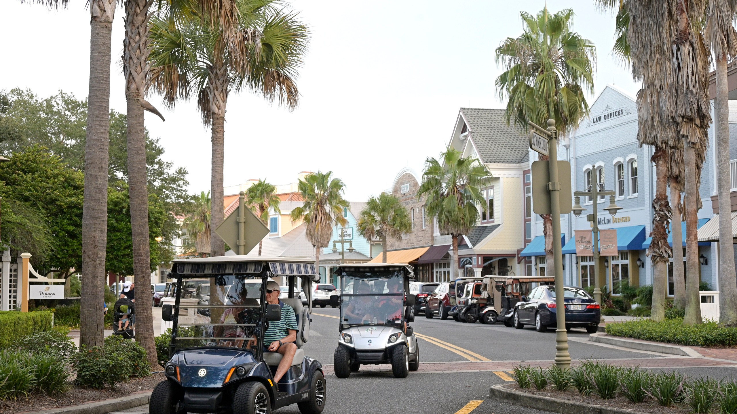 FILE - Residents drive golf carts through the Lake Sumter Landing Market Square on Aug. 12, 2021, in The Villages, Fla. A 77-year-old man in Florida has been arrested on a federal charge for obtaining misbranded erectile dysfunction drugs with the intent of distributing the medications throughout the enormous retirement community where he lives and elsewhere, authorities said. The man was arrested Sept. 2023, in The Villages, the sprawling retirement community of almost 80,000 fulltime residents in central Florida. (AP Photo/Phelan M. Ebenhack, File)