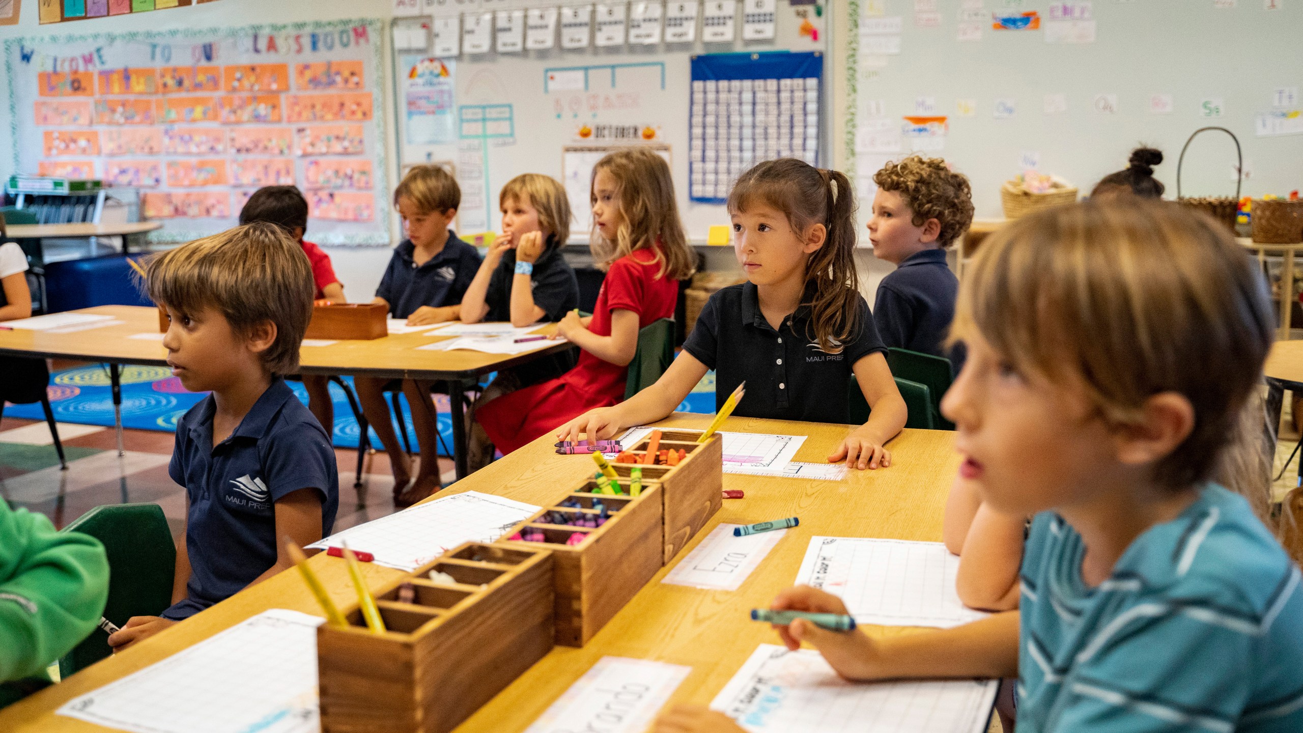 Maui Preparatory Academy students listen during an English lesson on Tuesday, Oct. 3, 2023, in Lahaina, Hawaii. Maui Preparatory Academy at one point had taken in about 150 public school students. The three public schools that survived the deadly August wildfire are set to reopen this week (AP Photo/Mengshin Lin)