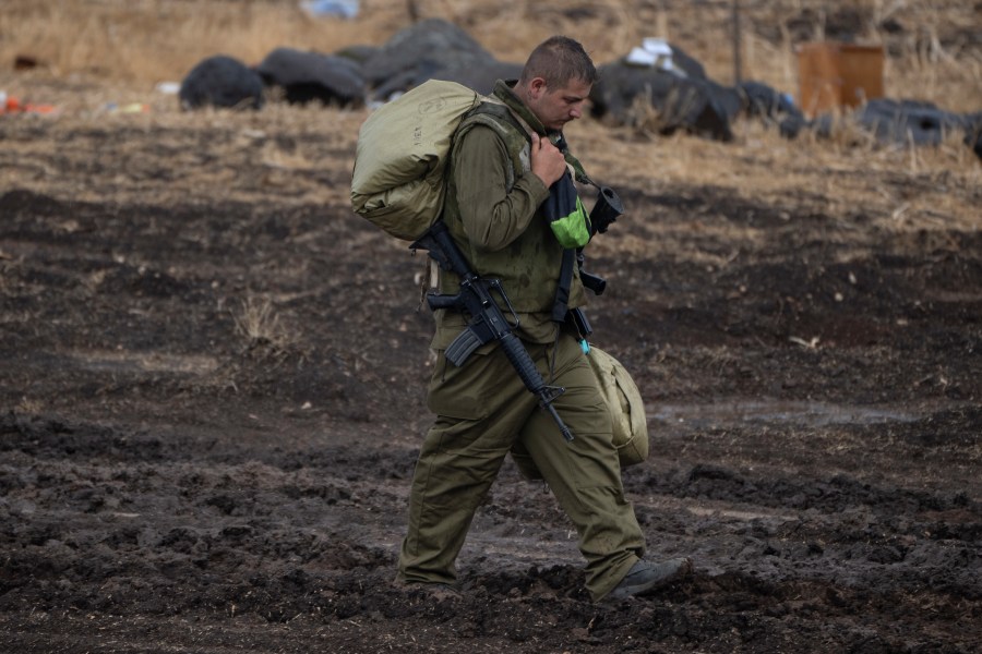 An Israeli soldier, walks during a rainfall near the Israeli border with Lebanon, on Sunday, Oct. 15, 2023.(AP Photo/Petros Giannakouris)