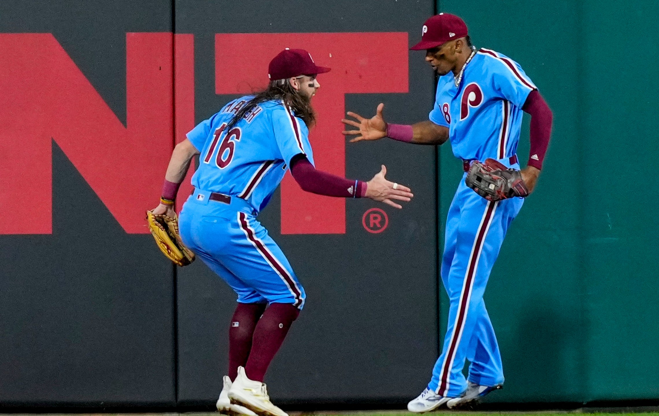 Philadelphia Phillies' Johan Rojas is congratulated by Brandon Marsh (16) after catching a long fly ball hit by Atlanta Braves' Ronald Acuna Jr. during the seventh inning of Game 4 of a baseball NL Division Series Thursday, Oct. 12, 2023, in Philadelphia. (AP Photo/Matt Rourke)