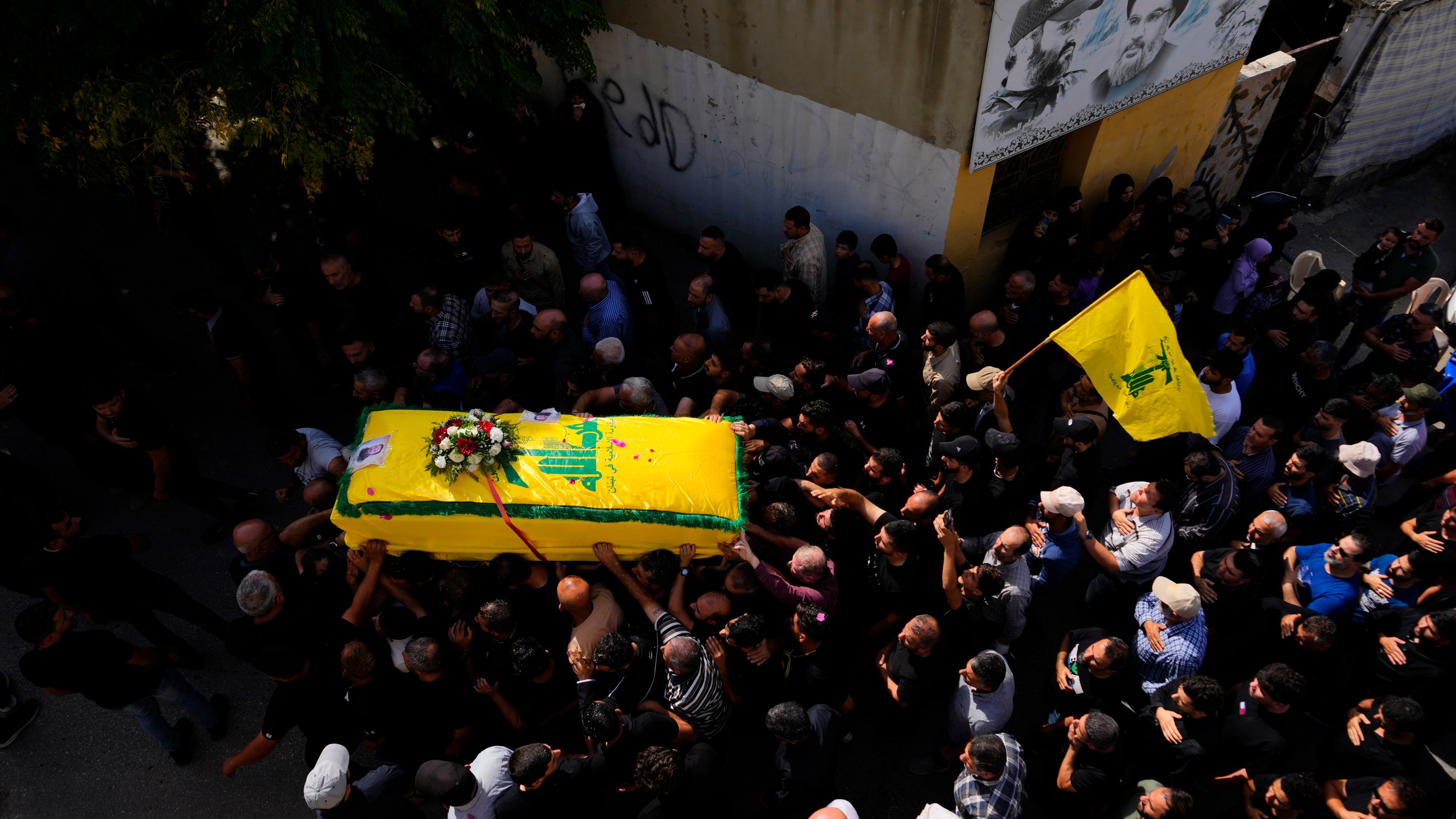 People carry the coffin of Hezbollah fighter, Bilal Nemr Rmeiti, who was killed by Israeli shelling, during his funeral procession in Majadel village, south Lebanon, Sunday, Oct. 22, 2023. (AP Photo/Hassan Ammar)