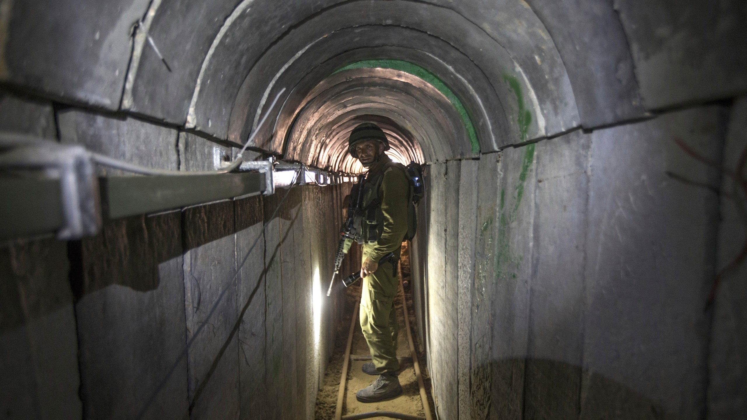 FILE - An Israeli army officer gives journalists a tour of a tunnel allegedly used by Palestinian militants for cross-border attacks, at the Israel-Gaza Border July 25, 2014. An extensive labyrinth of tunnels built by Hamas stretches across the dense neighborhoods of the Gaza Strip, hiding militants, their missile arsenal and the over 200 hostages they now hold after an unprecedented Oct. 7, 2023, attack on Israel. (AP Photo/Jack Guez, Pool, File)