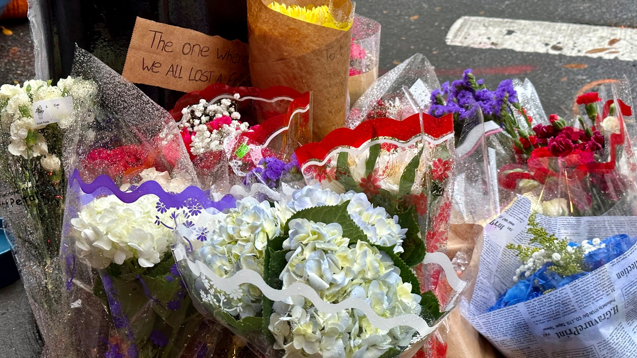 A makeshift memorial for Matthew Perry is seen outside the building known as the "Friends" building in New York, Sunday, Oct. 29, 2023. Fans lingered in the rain, taking pictures and leaving flowers on the corner outside the building shown in exterior shots on the popular TV show. Perry, who played Chandler Bing on NBC’s “Friends” for 10 seasons, was found dead at his Los Angeles home on Saturday. He was 54. (AP Photo/Brooke Lansdale)