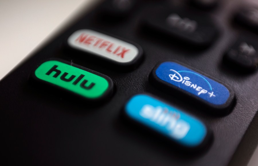 FILE - The logos for streaming services Netflix, Hulu, Disney Plus and Sling TV are pictured on a remote control on Aug. 13, 2020, in Portland, Ore. Walt Disney Co. said it will acquire a 33% stake in Hulu from Comcast for approximately $8.6 billion, a deal that will give Disney undisputed control of the streaming service. (AP Photo/Jenny Kane, File)