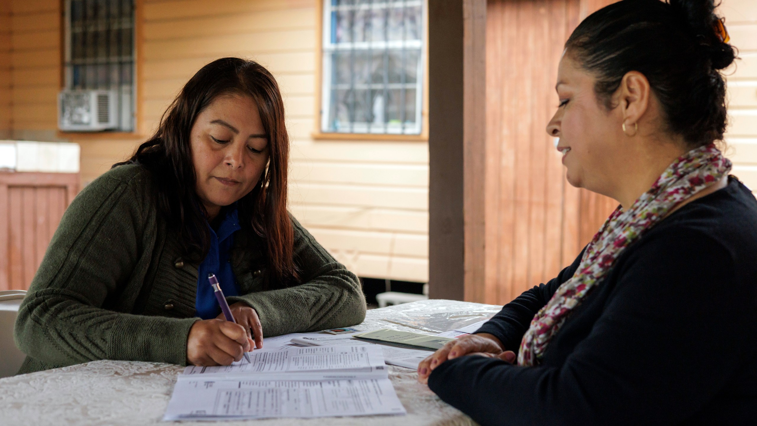 Children's Defense Fund program director Graciela Camarena assists Lucia Salazar with filling out Medicaid and SNAP application forms for her family in Pharr, Texas, Monday, Nov. 13, 2023. As the state reviews Texans' eligibility, some 1 million people have already lost Medicaid and organizations like the one Graciela works for assist people in applying again. (AP Photo/Michael Gonzalez)