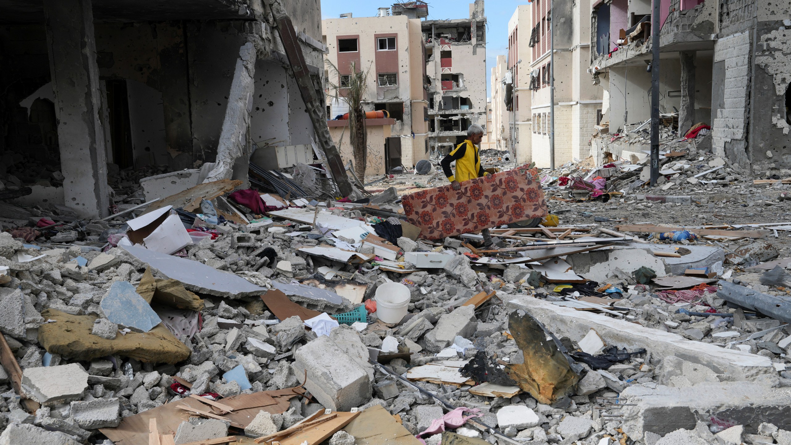 A Palestinian man collects his belongings southeast of the Gaza City on Tuesday, Nov. 28, 2023. on the fifth day of the temporary ceasefire between Hamas and Israel. (AP Photo/Adel Hana)