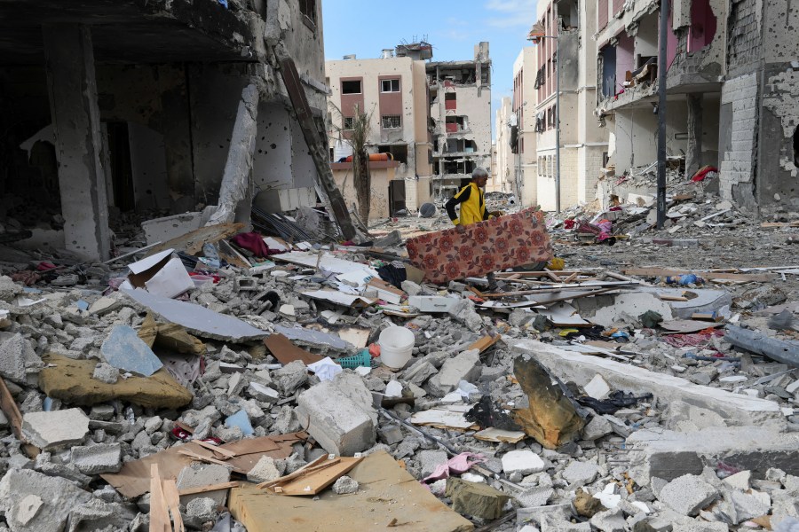 A Palestinian man collects his belongings southeast of the Gaza City on Tuesday, Nov. 28, 2023. on the fifth day of the temporary ceasefire between Hamas and Israel. (AP Photo/Adel Hana)