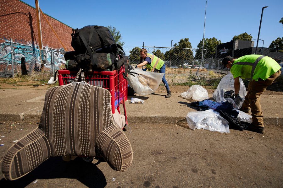 THIS CORRECTS THE NAME OF THE CONTRACTOR TO RAPID RESPONSE BIO CLEAN, NOT RAPID RESPONSE BIO CLEANUP AS ORIGINALLY SENT - Amber Nastasia, left, and Jacob Miller from Rapid Response Bio Clean clean a homeless camp in Portland, Ore., Thursday, July 27, 2023. Cities across the U.S. are struggling with and cracking down on tent encampments as the number of homeless people grows, largely due to a lack of affordable housing. Homeless people and their advocates say sweeps are cruel and costly, and there aren't enough homes or beds for everyone. (AP Photo/Craig Mitchelldyer)