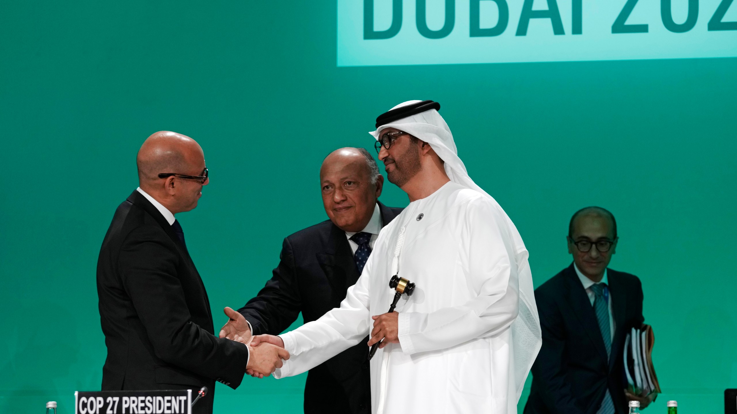 United Nations Climate Chief Simon Stiell, left, Sameh Shoukry, COP27 president, center, and COP28 President Sultan al-Jaber shake hands as they attend the opening session at the COP28 U.N. Climate Summit, Thursday, Nov. 30, 2023, in Dubai, United Arab Emirates. (AP Photo/Peter Dejong)