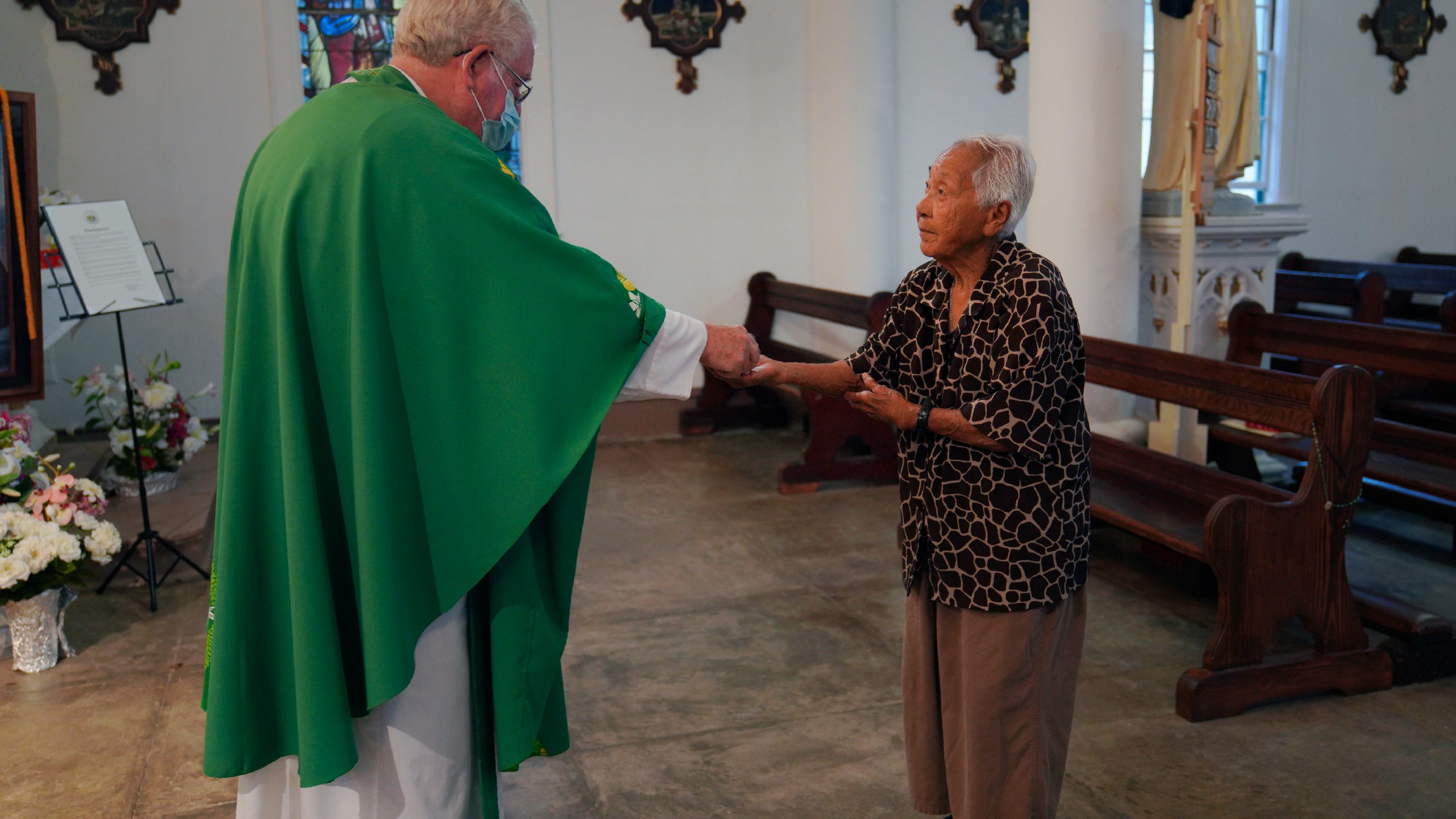 The Rev. Patrick Killilea gives communion to Meli Watanuki, at Mass on Wednesday, July 19, 2023, in Kalaupapa, Hawaii. In the 1800s, the peninsula was a settlement for banished leprosy patients, later called Hansen's disease. (AP Photo/Jessie Wardarski)