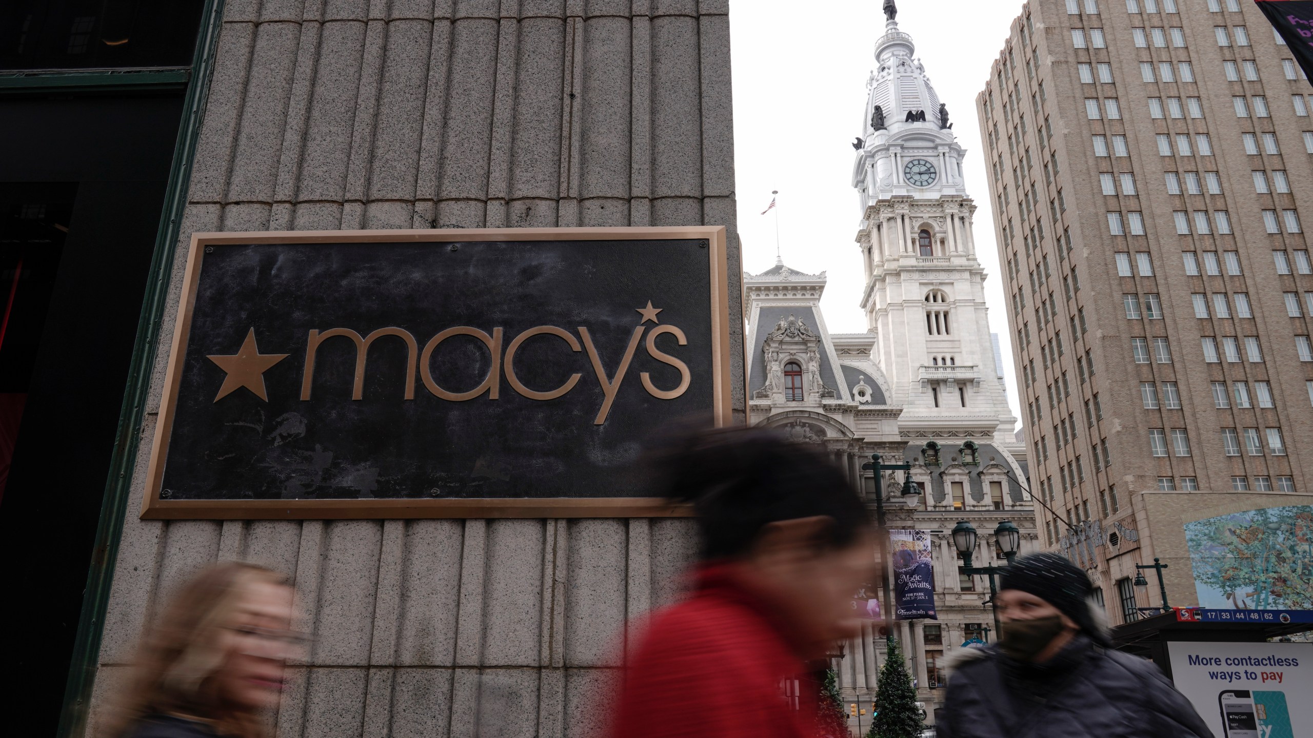 People walk past a closed Macy's retail location after reports of an alleged stabbing at the department store, Monday, Dec. 4, 2023, in view of City Hall in Philadelphia. Philadelphia police say a man stabbed two security guards, killing one and injuring the other. (AP Photo/Matt Rourke)