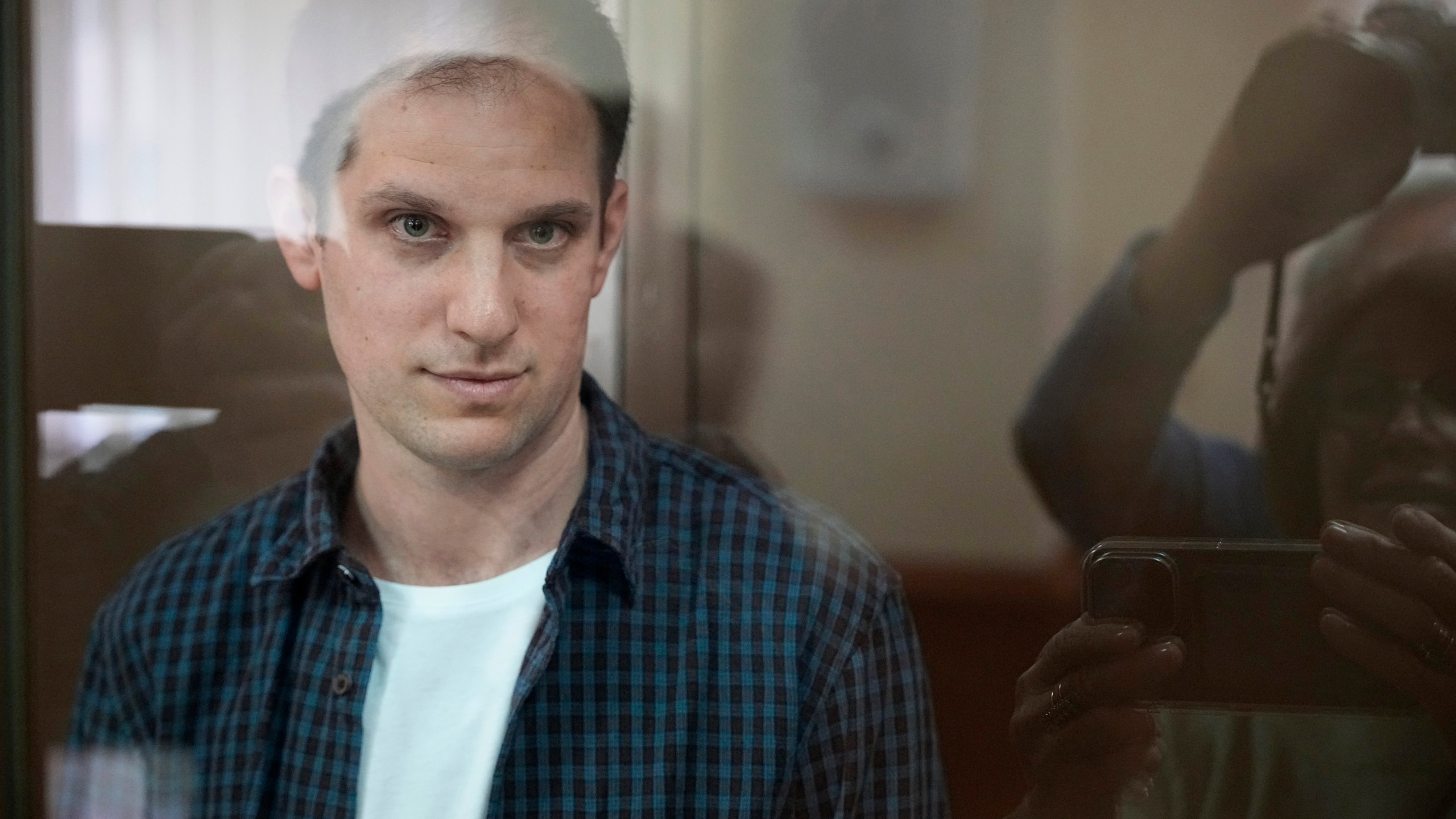 FIle - Wall Street Journal reporter Evan Gershkovich stands in a glass cage in a courtroom at the Moscow City Court, in Moscow, Russia, Oct. 10, 2023. The Biden administration says its made a new and significant offer aimed at securing the release of American detainees Paul Whelan and Evan Gershkovich, but Russia has rejected the offer. (AP Photo/Alexander Zemlianichenko, File)