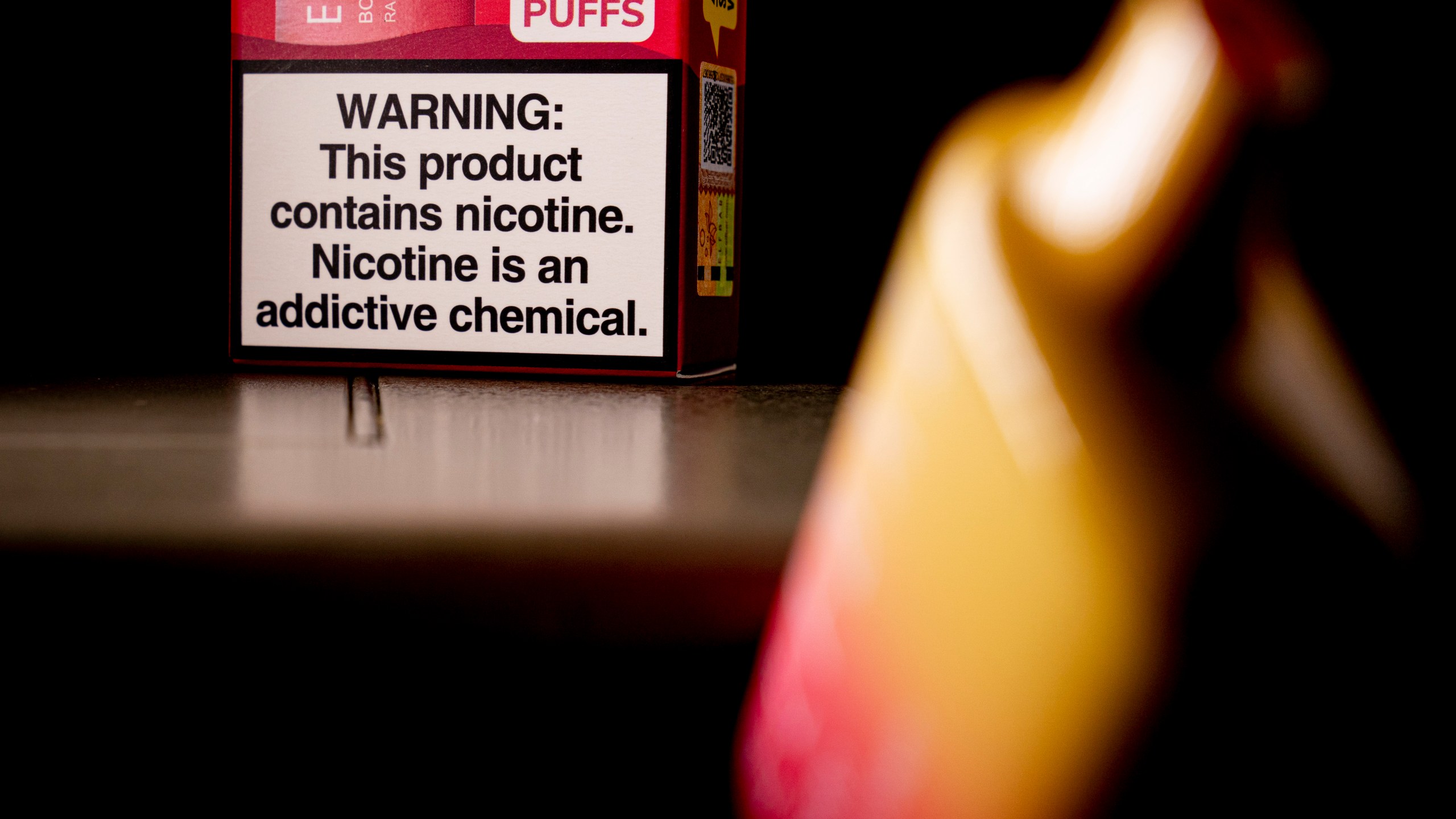 FILE - An Elf Bar disposable vaping pod device and a health warning on its packaging is displayed, Monday, June 26, 2023, in Washington. U.S. lawmakers are demanding information on federal efforts to stop the recent influx of kid-appealing electronic cigarettes from China. A letter sent Thursday, Dec. 7, 2023, by a congressional committee investigating Chinese policies called attention to “the extreme proliferation of illicit vaping products.” (AP Photo/Andrew Harnik, File)