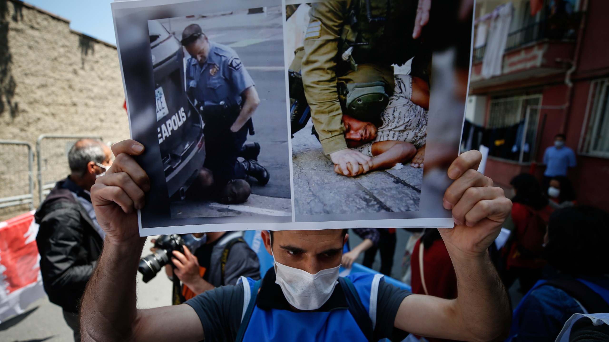 FILE - A demonstrator holds a placard with photos of George Floyd, left, a black man who died after being restrained by Minneapolis police officers on May 25, 2020 and an undated photo, right, of an Israeli soldier restraining a Palestinian youth, during a protest near the U.S. consulate in Istanbul, Thursday, June 4, 2020. A growing number of Black Americans see the struggle of Palestinians reflected in their own fights for freedom and civil rights. In recent years, the rise of protest movements in the U.S. against police brutality in the U.S., where structural racism plagues nearly every facet of life, has connected Black and Palestinian activists under a common cause. But that kinship sometimes strains the alliance between Black and Jewish activists, which extends back several decades. (AP Photo/Emrah Gurel, File)