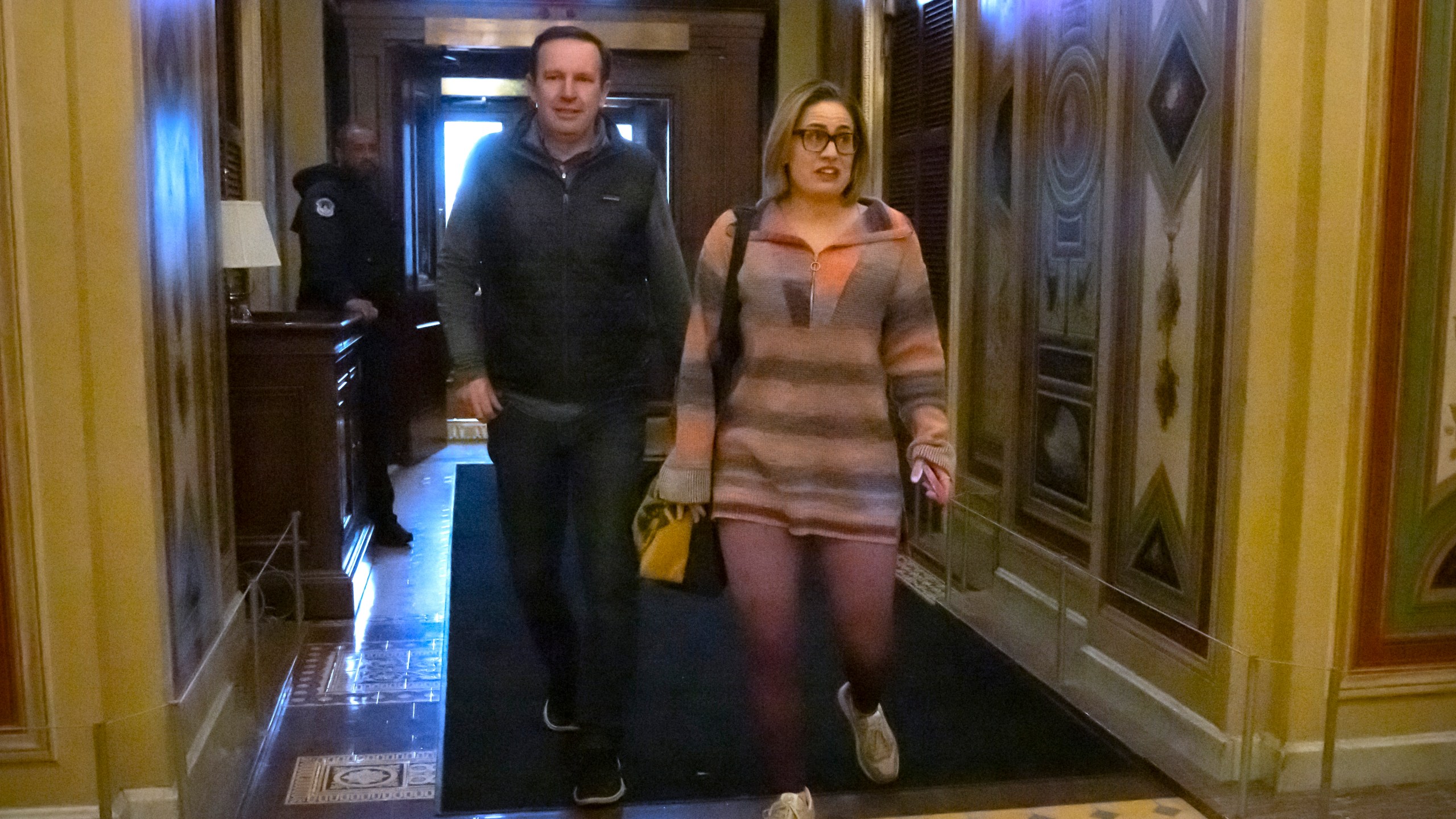 Sen. Chris Murphy, D-Conn., left, and Sen. Kyrsten Sinema, I-Ariz., right, arrive for closed-door negotiations on a border security deal at the Capitol, Sunday, Dec. 17, 2023, in Washington. Negotiators are rushing to reach a U.S. border security deal that would unlock President Joe Biden's request for billions of dollars worth in military aid for Ukraine and national security. (AP Photo/Mark Schiefelbein)