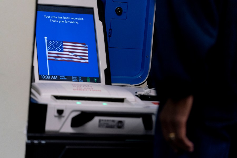 FILE - A voter submits their ballot at an early voting location in Alexandria, Va., Sept. 26, 2022. A declassified U.S. government report says foreign hackers did not change vote totals or otherwise compromise the integrity of federal elections last year in the United States. The report does identify multiple instances in which hackers linked to Iran, China and Russia connected to election infrastructure, scanned state government websites and copied voter information. (AP Photo/Andrew Harnik, File)