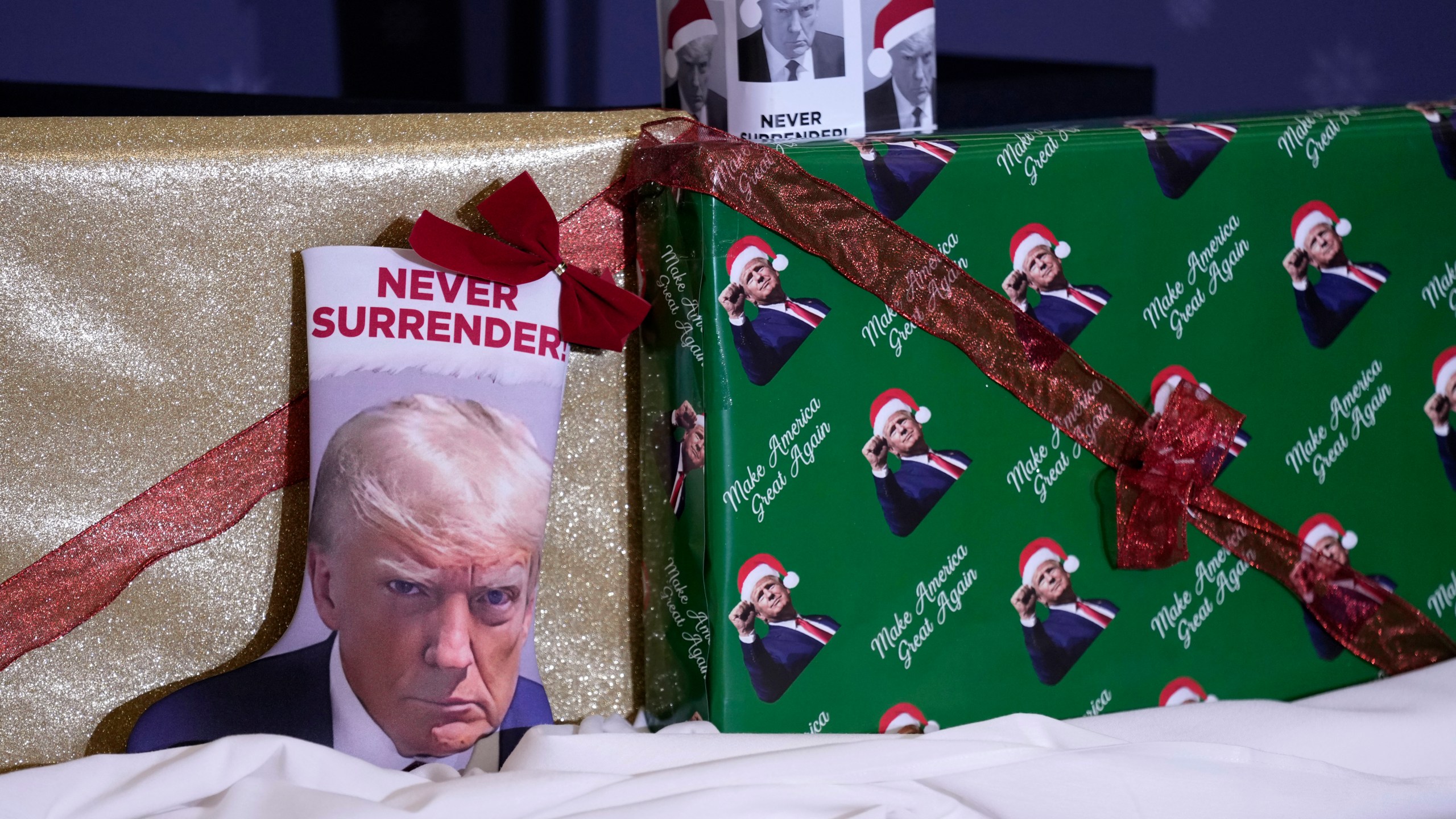 Christmas gifts are seen on the stage during a former President Donald Trump commit to caucus rally, Tuesday, Dec. 19, 2023, in Waterloo, Iowa. (AP Photo/Charlie Neibergall)