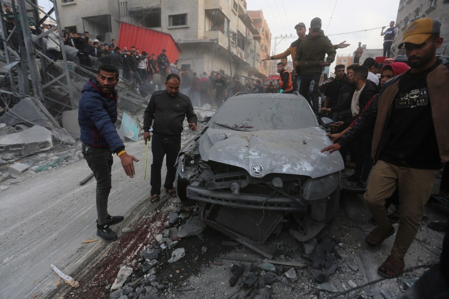 Palestinians look at the destruction after an Israeli strike in Rafah, Gaza Strip, Wednesday, Dec. 20, 2023. (AP Photo/Hatem Ali)