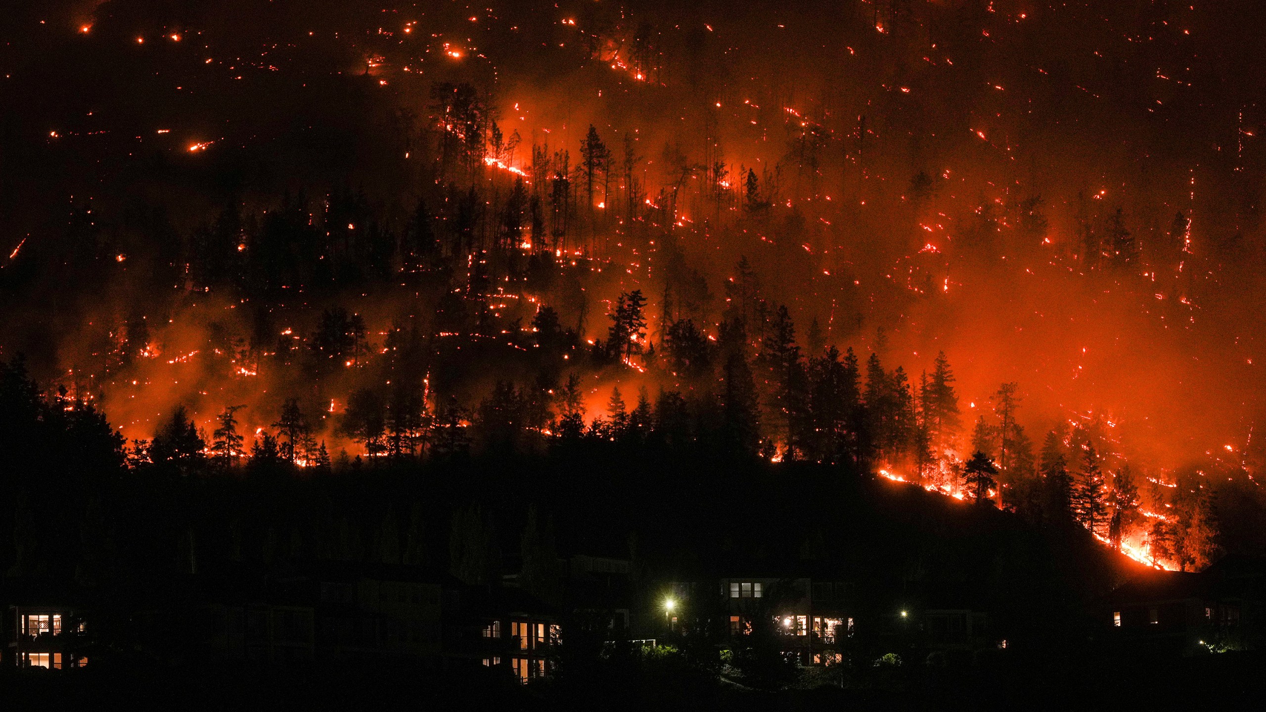 The McDougall Creek wildfire burns on the mountainside above houses in West Kelowna, British Columbia, on Aug. 18, 2023. This year was Canada's worst fire season on record. (Darryl Dyck/The Canadian Press via AP)