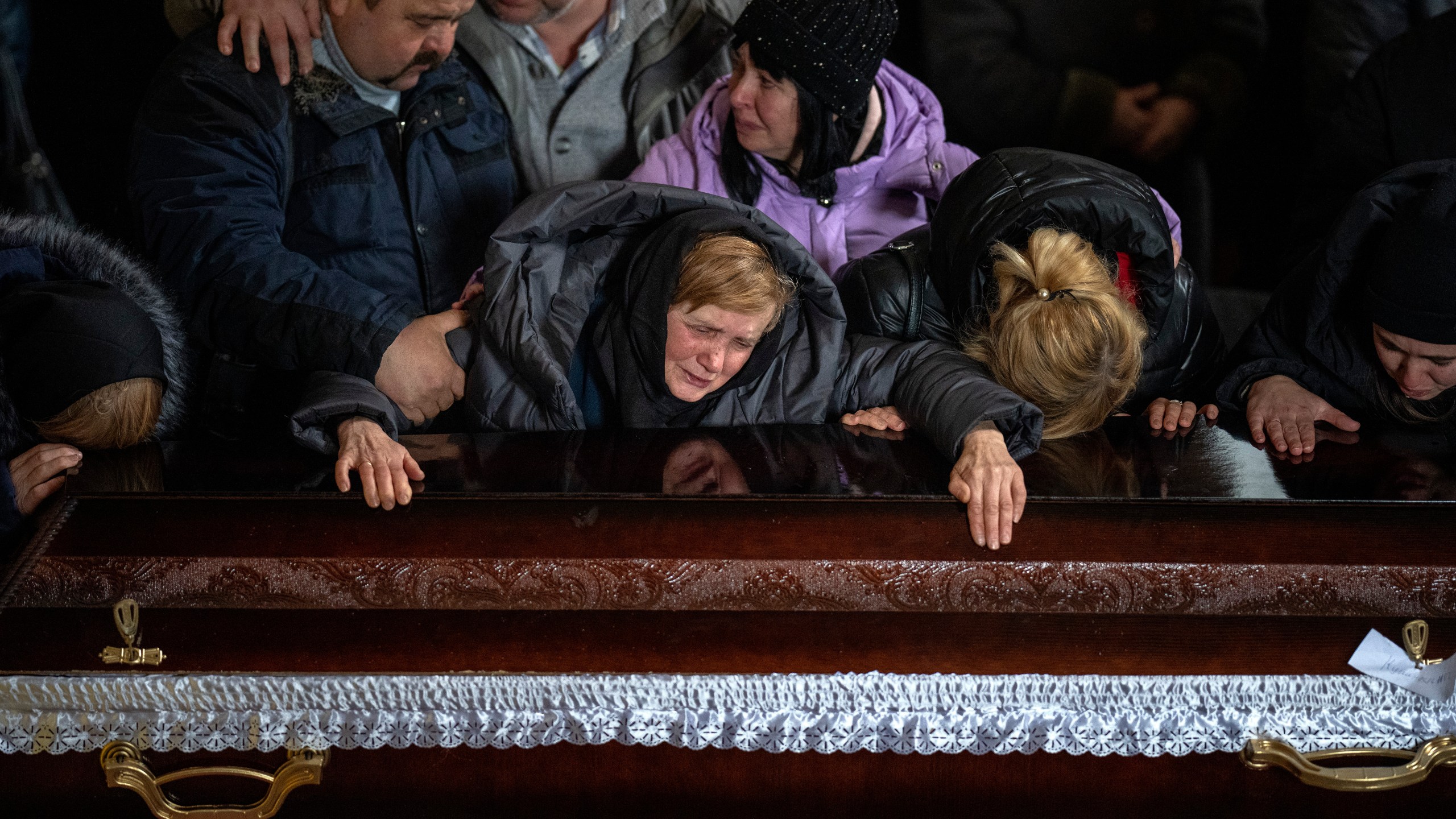 Nadia cries over the coffin of her son Oleg Kunynets, a Ukrainian military servicemen who was killed in the east of the country, during his funeral in Lviv, Ukraine, Tuesday, Feb 7, 2023. (AP Photo/Emilio Morenatti)