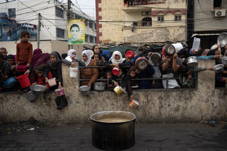 Palestinians line up for a free meal in Rafah, Gaza Strip, Thursday, Dec. 21, 2023. International aid agencies say Gaza is suffering from shortages of food, medicine and other basic supplies as a result of the two and a half month war between Israel and Hamas. (AP Photo/Fatima Shbair)