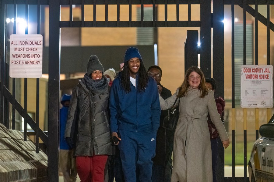 Darien Harris, flanked by his mother Nakesha Harris, left, and his lawyer walk past the gate of Cook County Jail after prosecutors dropped charges on Harris for a fatal shooting in 2011 in a Woodlawn gas station he was convicted for and was serving a 76 year long sentence, Tuesday, Dec. 19, 2023, in Cook County, Ill. (Tyler Pasciak LaRiviere/Chicago Sun-Times via AP)