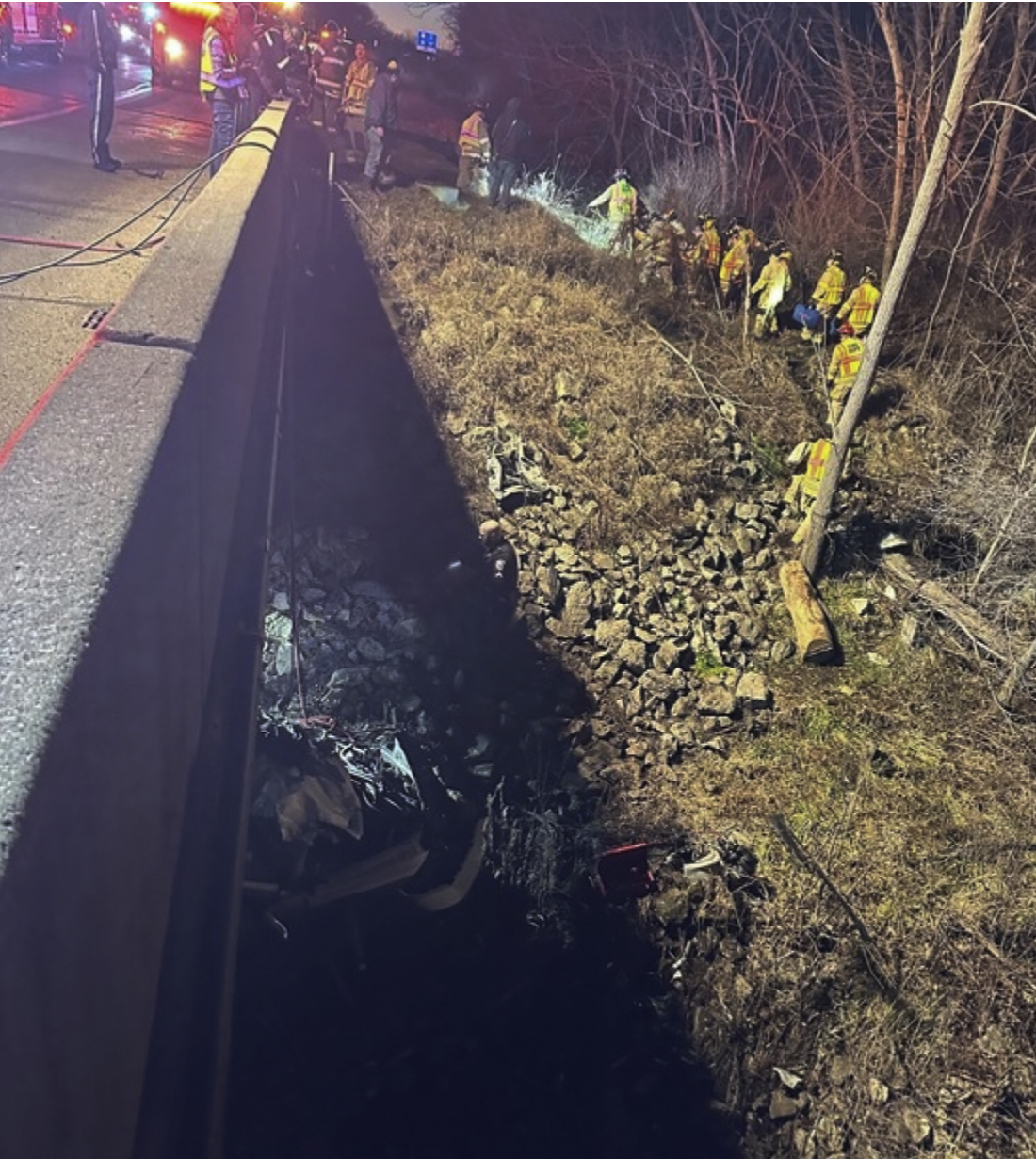 This photo provided by the Indiana State Police, police rescue a man after finding his damaged vehicle Tuesday, Dec. 26, 2023 along Interstate 94 near Portage, Ind. Police say the man who was rescued after being trapped for six days in his crashed pickup truck drank rainwater to survive the ordeal while pinned in the wreckage beneath the Indiana highway bridge. (Indiana State Police via AP)