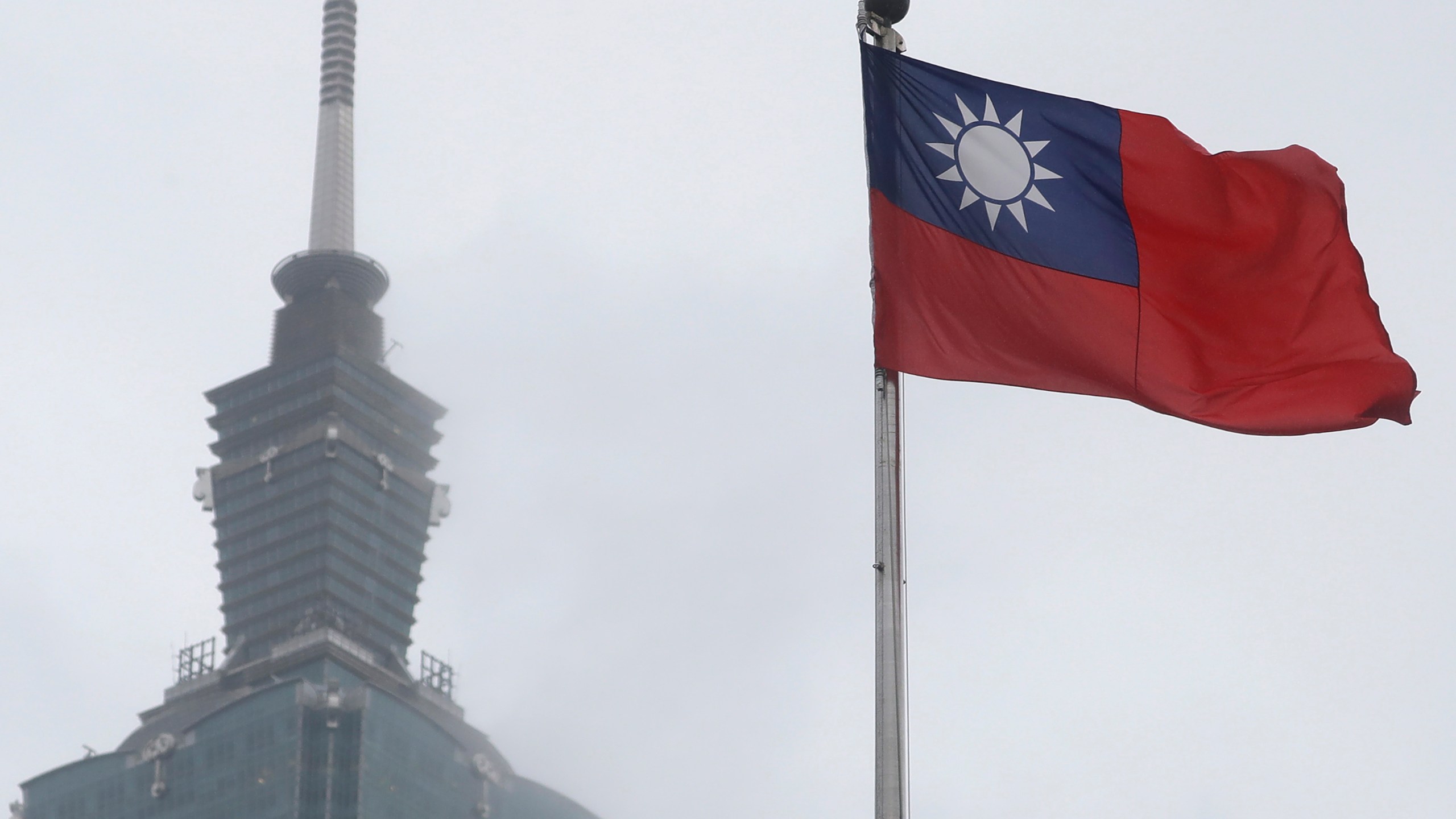 FILE - A Taiwan national flag flutters near the Taipei 101 building at the National Dr. Sun Yat-Sen Memorial Hall in Taipei, Taiwan, on May 7, 2023. Weeks before Taiwan holds elections for its president and legislature, China has renewed its threat to use military force to annex the self-governing island democracy it claims as its own territory. (AP Photo/Chiang Ying-ying, File)