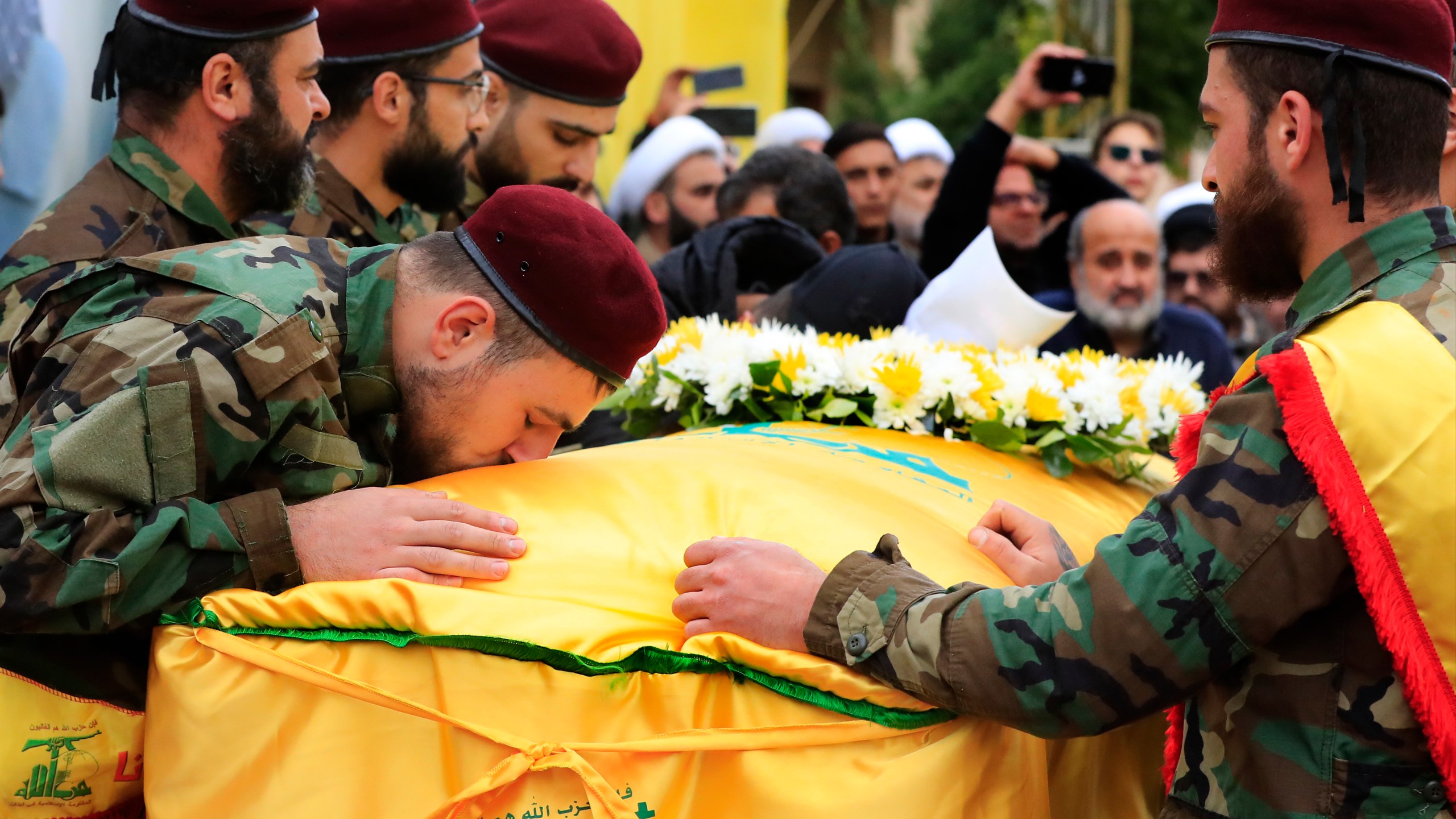 A Hezbollah fighter kisses the coffin of his comrade Ali Bazzi, who was killed with other two civilians by an Israeli airstrike that hit their house Tuesday night, during his funeral procession, in Bint Jbeil, South Lebanon, Wednesday, Dec. 27, 2023. One Hezbollah fighter and two civilians, a newlywed couple, were killed in an overnight Israeli strike on a family-owned residential building in the town of Bint Jbeil, local residents and state media said Wednesday.(AP Photo/Mohammed Zaatari)