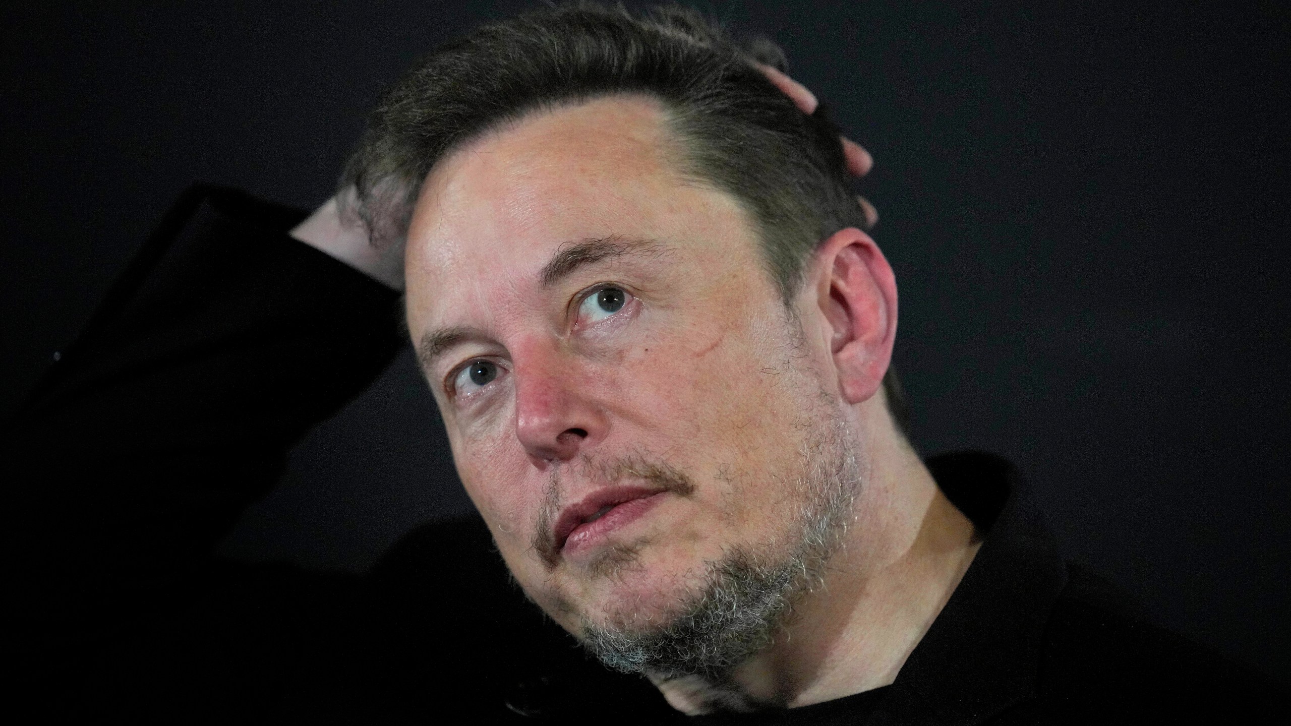 FILE - Elon Musk reacts during an in-conversation event with Britain's Prime Minister Rishi Sunak in London, on Nov. 2, 2023. A little more than a year ago, Elon Musk walked into Twitter's San Francisco headquarters, fired its CEO and other top executives and began transforming the social media platform into what's now known as X. (AP Photo/Kirsty Wigglesworth, Pool, File)