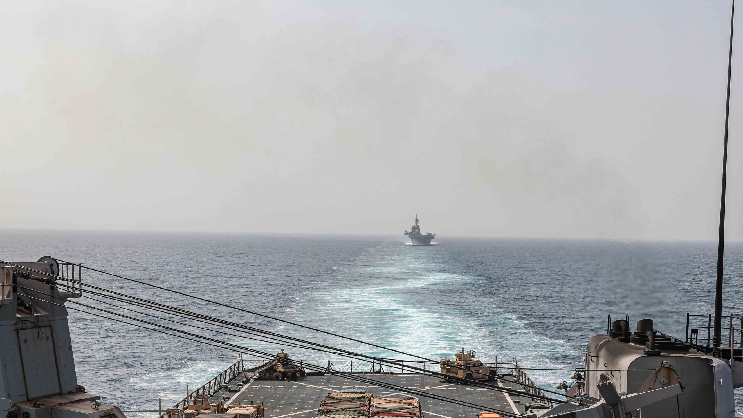 In this image provided by the U.S. Navy, the amphibious dock landing ship USS Carter Hall and amphibious assault ship USS Bataan transit the Bab al-Mandeb strait on Aug. 9, 2023. The top commander of U.S. naval forces in the Middle East says Yemen’s Houthi rebels are showing no signs of ending their “reckless” attacks on commercial ships in the Red Sea. But Vice Adm. Brad Cooper said in an Associated Press interview on Saturday that more nations are joining the international maritime mission to protect vessels in the vital waterway and trade traffic is beginning to pick up. (Mass Communications Spc. 2nd Class Moises Sandoval/U.S. Navy via AP)