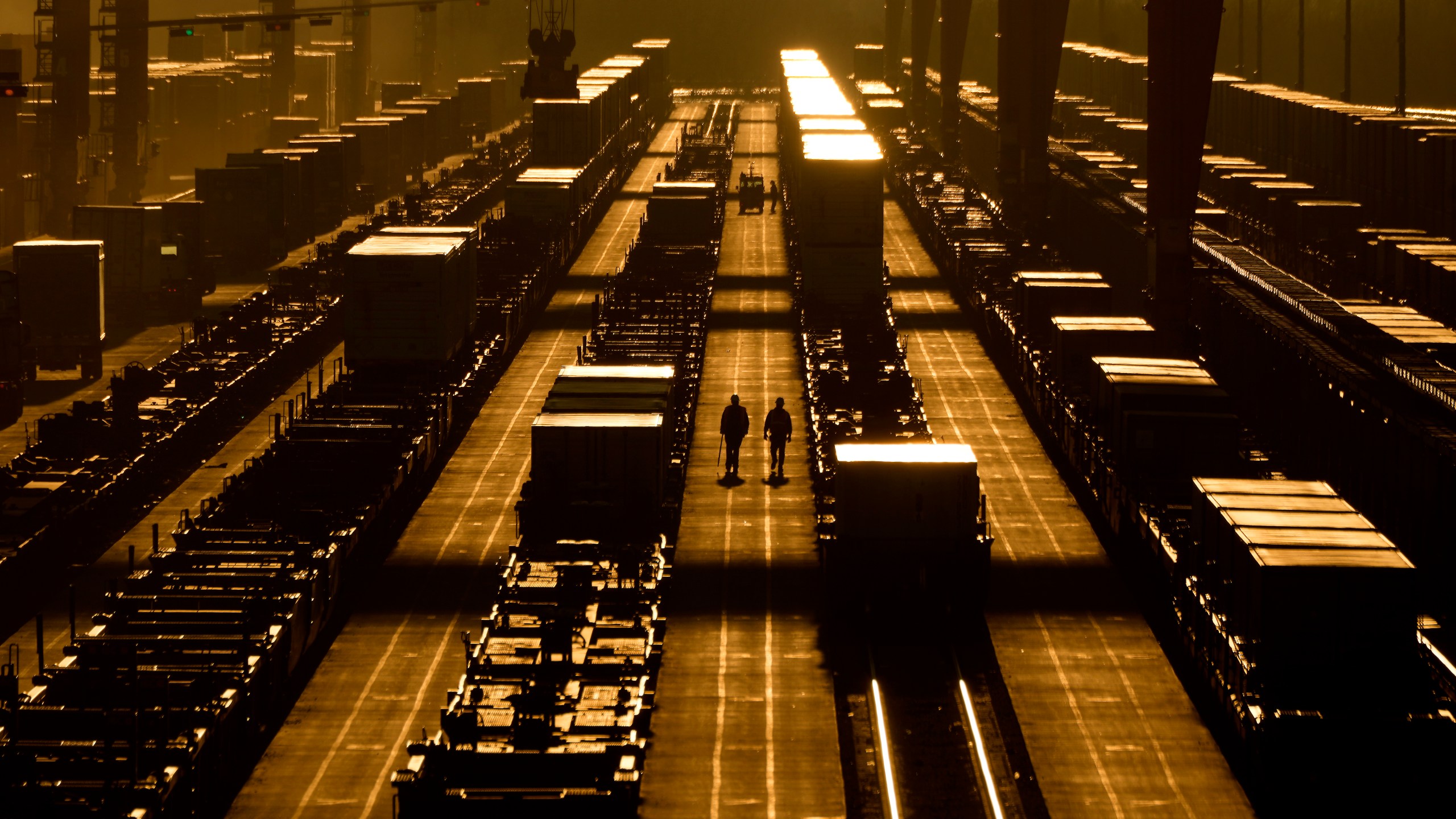 Workers walk among shipping containers at a BNSF intermodal terminal, Wednesday, Jan. 3, 2024, in Edgerton, Kan. On Friday, the U.S. government issues its December jobs report. (AP Photo/Charlie Riedel)