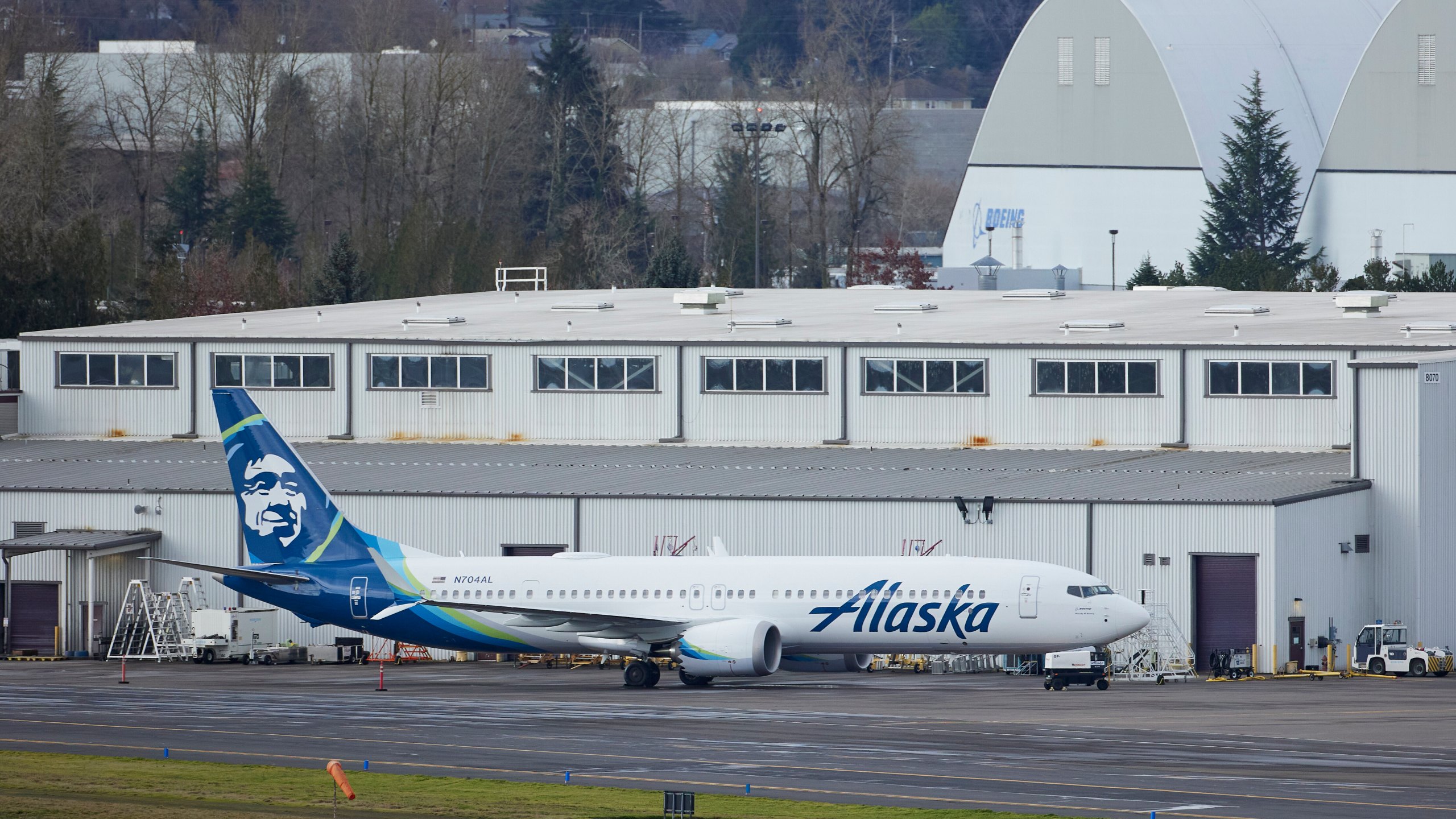 Alaska Airlines N704AL, a 737 Max 9 which made an emergency landing at Portland International Airport after a part of the fuselage broke off mid-flight on Friday, is parked at a maintenance hanger in Portland, Ore., Saturday, Jan. 6, 2024. (AP Photo/Craig Mitchelldyer)