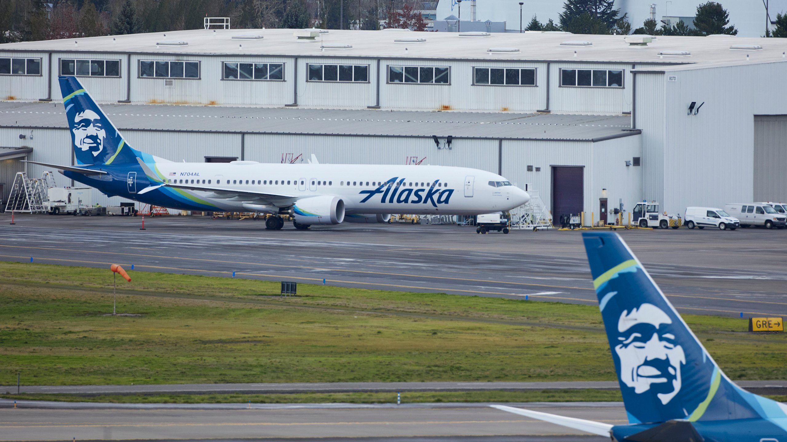 Alaska Airlines N704AL, a 737 Max 9 which made an emergency landing at Portland International Airport after a part of the fuselage broke off mid-flight on Friday, is parked at a maintenance hanger in Portland, Ore., Saturday, Jan. 6, 2024. (AP Photo/Craig Mitchelldyer)