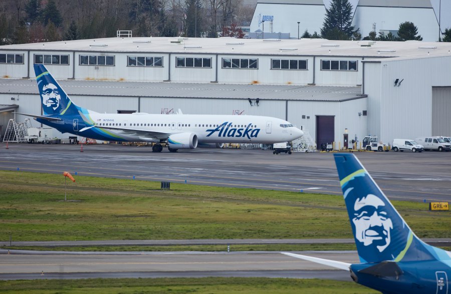 Alaska Airlines N704AL, a 737 Max 9 which made an emergency landing at Portland International Airport after a part of the fuselage broke off mid-flight on Friday, is parked at a maintenance hanger in Portland, Ore., Saturday, Jan. 6, 2024. (AP Photo/Craig Mitchelldyer)