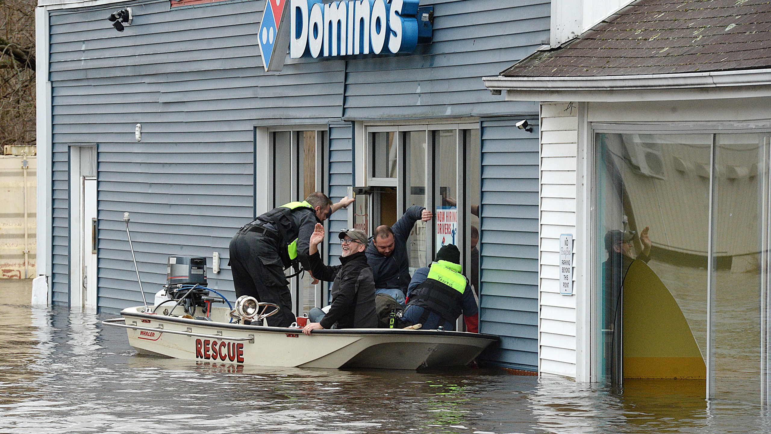 Mark Massey, second from left, and Keith Santor, second from right, are rescued Wednesday, Jan. 10, 2024, by the Yantic Fire Department during flooding in Norwich, Conn. (Dana Jensen/The Day via AP)