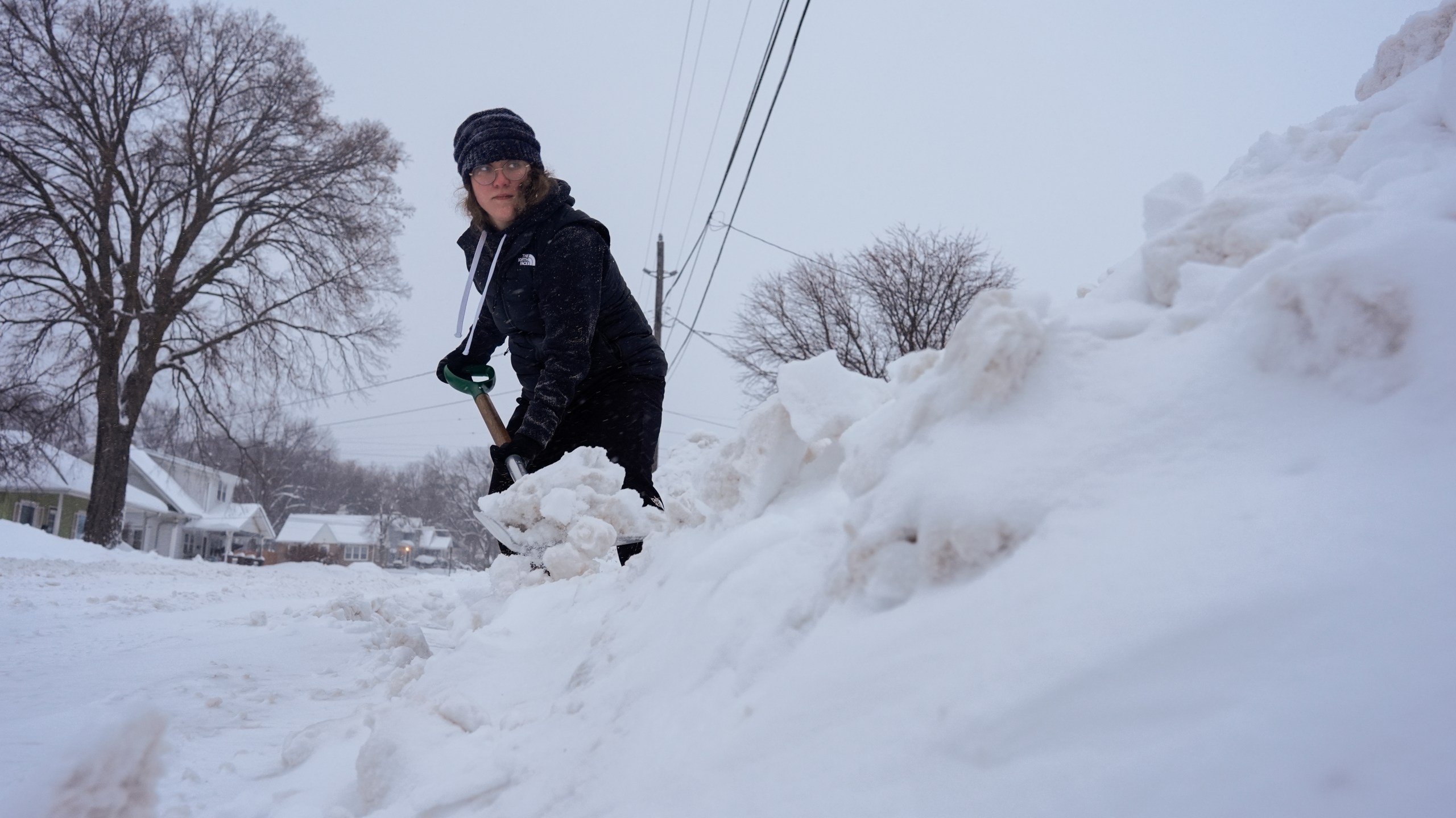 Graphic designer Emily Brewer shovels out her driveway in order to drive to work in Sioux City, Iowa, early on Friday, Jan. 12, 2024. (AP Photo/Carolyn Kaster)