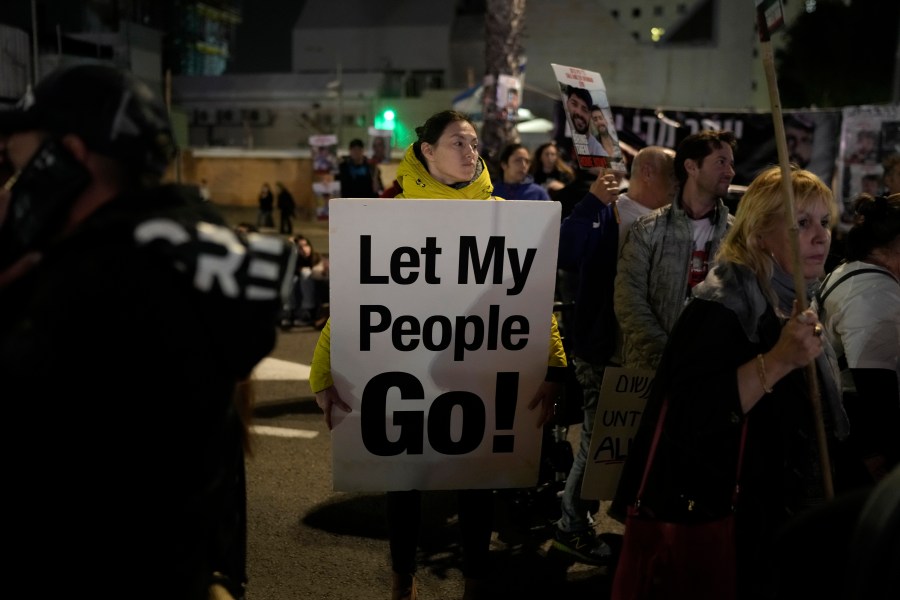 A woman holds a sign calling for the release of the hostages taken by Hamas militants into the Gaza Strip at the Hostages Square in Tel Aviv, Israel, Saturday Jan. 13, 2024. Sunday marks 100 days that Israel and Hamas have been at war after Hamas' cross-border attack on Oct. 7 in which the group killed some 1,200 people, mostly civilians, and took 250 others hostage. In the Gaza Strip, health authorities say the death toll already has eclipsed 23,000 people, roughly 1% of the Palestinian territory's population. Thousands more remain missing or badly wounded.(AP Photo/Leo Correa)