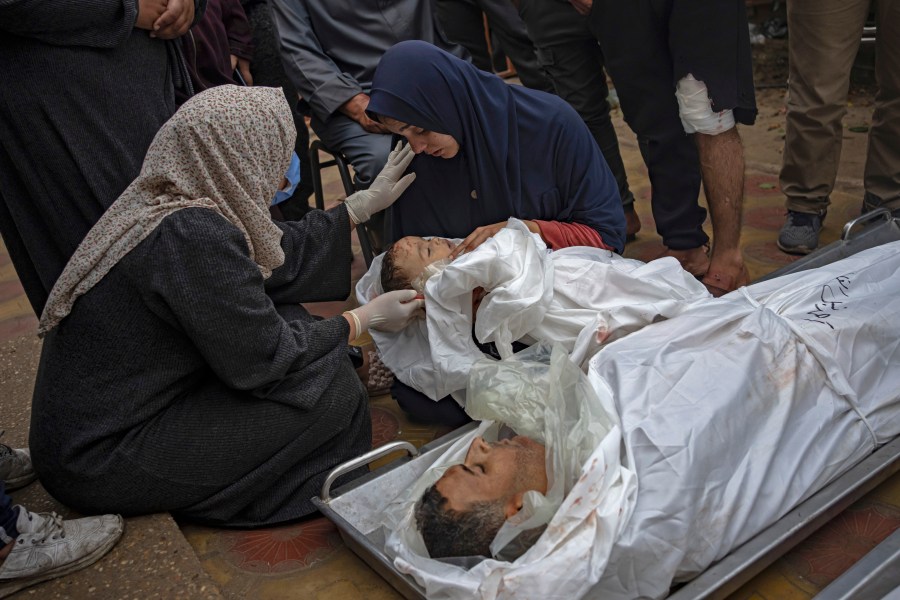 FILE - A Palestinian woman mourns her child and her husband killed in an Israeli army bombardment of the Gaza Strip, outside the hospital in Khan Younis, Tuesday Dec. 5, 2023. Now 100 days old, the latest Israel-Hamas war is by far the longest, bloodiest, and most destructive conflict between the bitter enemies. The fighting erupted on Oct. 7, 2023 when Hamas carried out a deadly attack in southern Israel. Since then, Israel has relentlessly pounded the Gaza Strip with airstrikes and a ground offensive that have wrought unprecedented destruction, flattening entire neighborhoods. (AP Photo/Fatima Shbair, File)