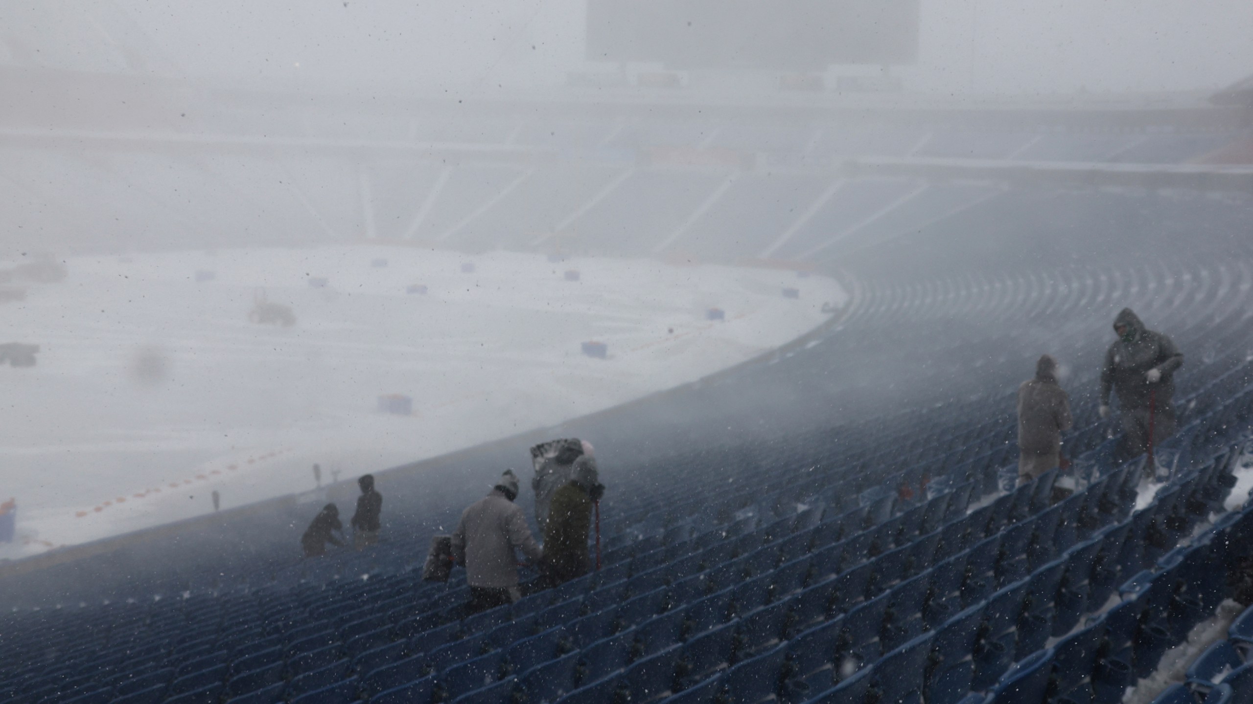 Workers remove snow from Highmark Stadium in Orchard Park, N.Y., Sunday Jan. 14, 2024. A potentially dangerous snowstorm that hit the Buffalo region on Saturday led the NFL to push back the Bills wild-card playoff game against the Pittsburgh Steelers from Sunday to Monday. New York Gov. Kathy Hochul and the NFL cited public safety concerns for the postponement, with up to 2 feet of snow projected to fall on the region over a 24- plus hour period. (AP Photo/ Jeffrey T. Barnes)