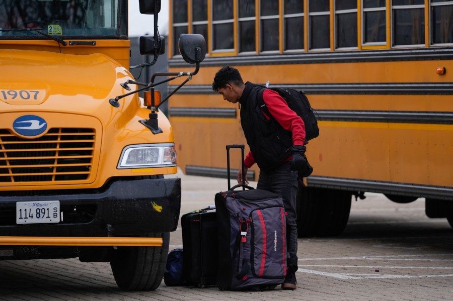 An arriving migrant departs a school bus in the 800 block of South Desplaines Street where Chicago Transit Authority "warming" buses for migrants are parked Thursday, Jan. 11, 2024, in Chicago. In the city of Chicago's latest attempt to provide shelter to incoming migrants, several buses were parked in the area to house people in cold winter weather. (AP Photo/Erin Hooley)