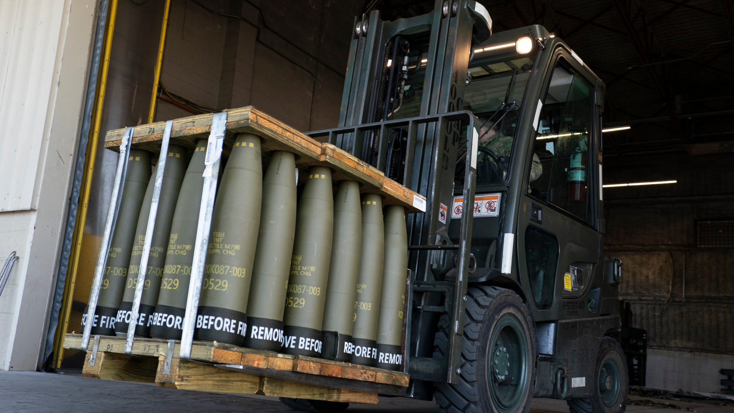 FILE - Airmen with the 436th Aerial Port Squadron use a forklift to move 155 mm shells ultimately bound for Ukraine, April 29, 2022, at Dover Air Force Base, Del. For almost 20 months the Pentagon has spearheaded a monthly gathering of about 50 allies where the U.S. has led the way in sending billions of dollars in aid to Kyiv. But on Jan. 23, 2024, for the first time since Secretary of Defense Lloyd Austin established the group in April of 2022, the U.S. will come to the table out of money, unable to send Ukraine the ammunition and missiles it needs to fend off Russia. (AP Photo/Alex Brandon, File)