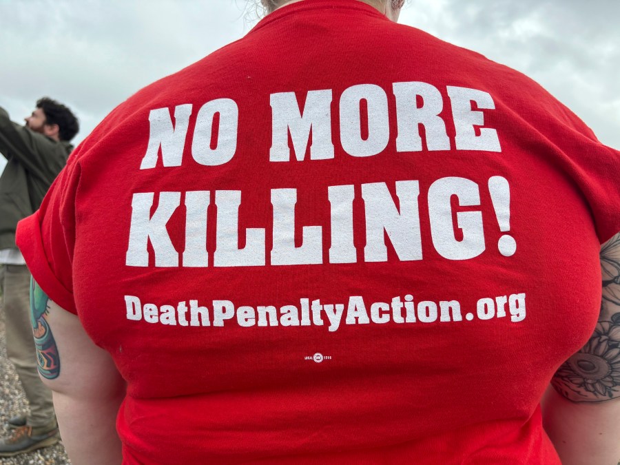 Anti-death penalty activists place signs along the road heading to Holman Correctional Facility in Atmore, Alabama.