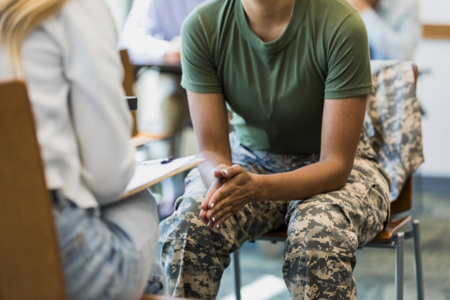 A female soldier seated with another person.