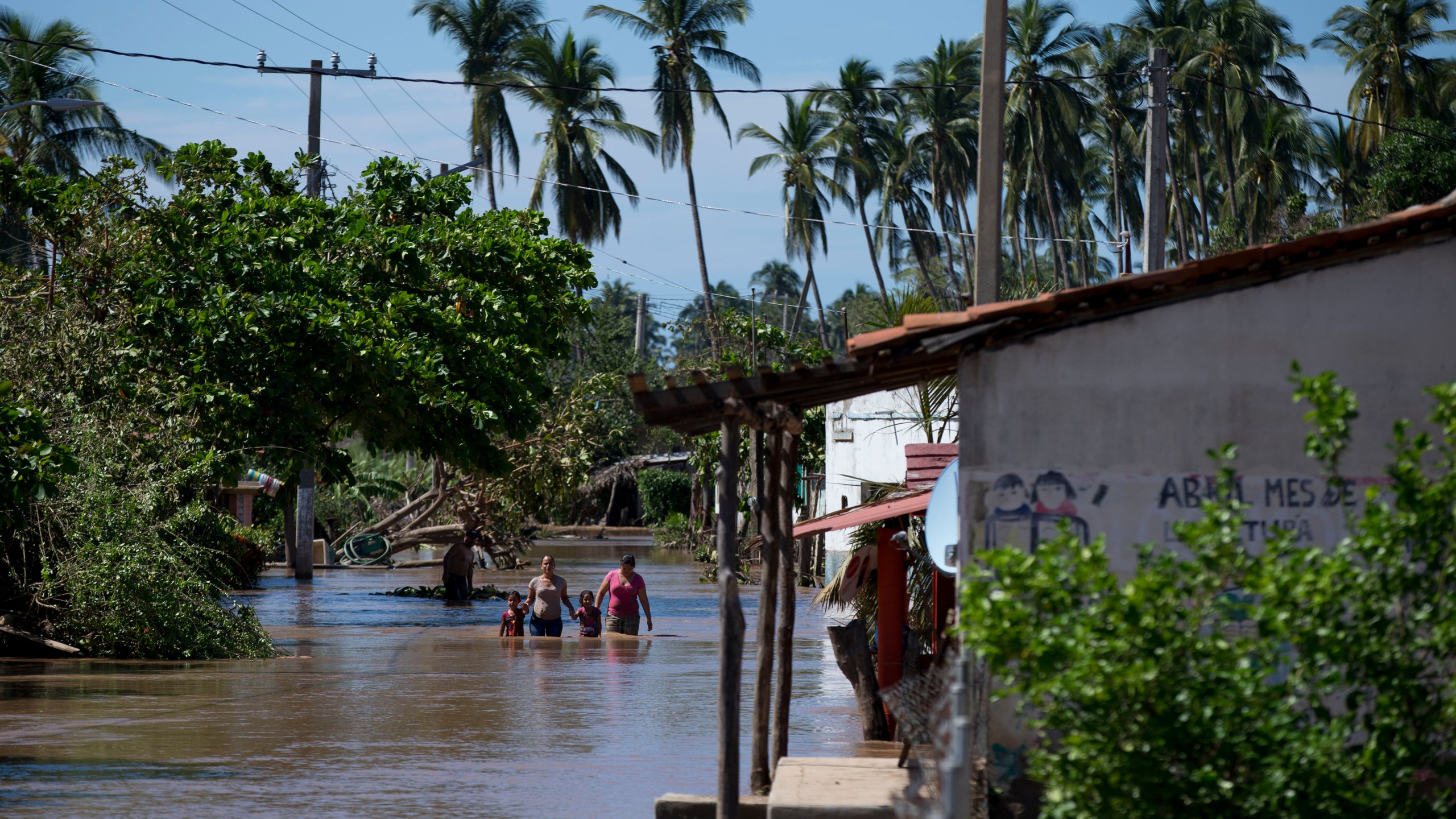 FILE - Residents wade down a street through receding floodwaters, two days after Hurricane Patricia, in the village of Rebalse, Jalisco State, Mexico, Oct. 25, 2015. A handful of powerful tropical storms in the last decade and the prospect of more to come has some experts proposing a new category of hurricanes: Category 6, which would be for storms with wind speeds of 192 miles per hour or more. (AP Photo/Rebecca Blackwell, File)