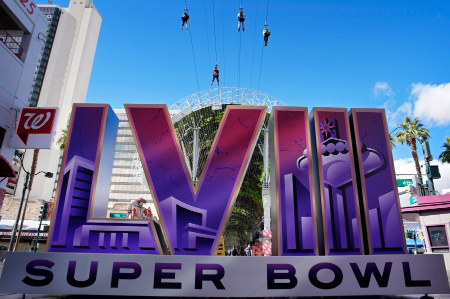 People ride a zip line above a sign for the Super Bowl ahead of the Super Bowl 58 NFL football game, Friday, Feb. 2, 2024, in Las Vegas. Las Vegas is scheduled to host the Super Bowl 58 on Sunday, Feb. 11, 2024. (AP Photo/John Locher)